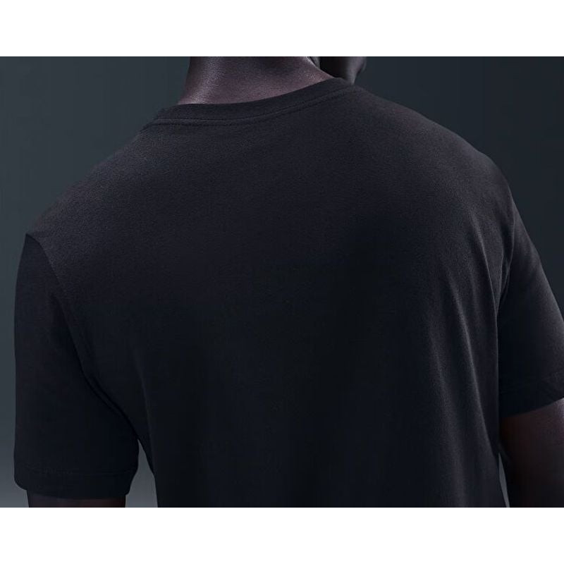 Gros plan du logo brodé du Paris Saint-Germain sur la poitrine gauche d'un t-shirt en coton bleu Nik