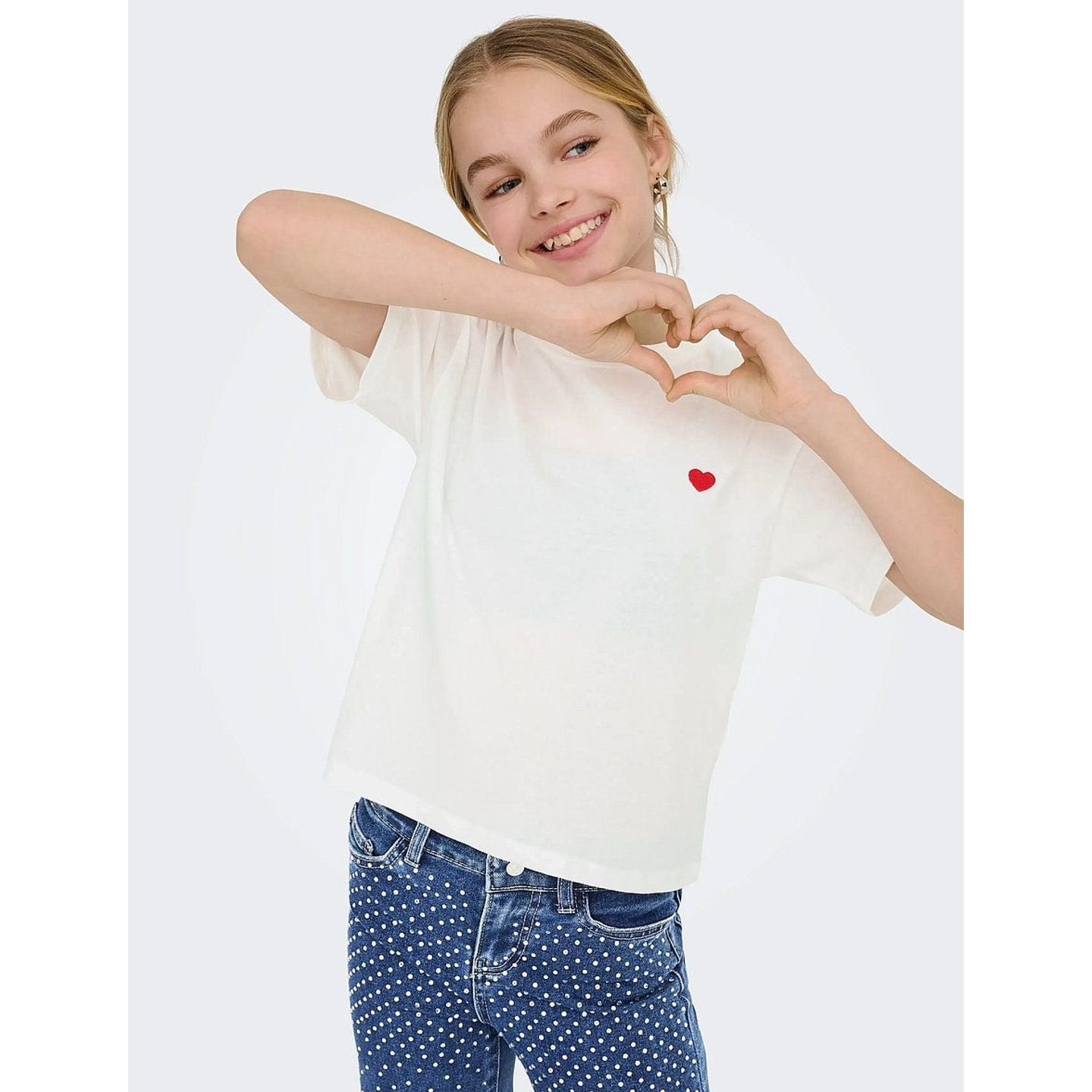 Vue arrière lifestyle d'une fille en t-shirt cropped bleu Kids Only, coupe décontractée et ourlet co