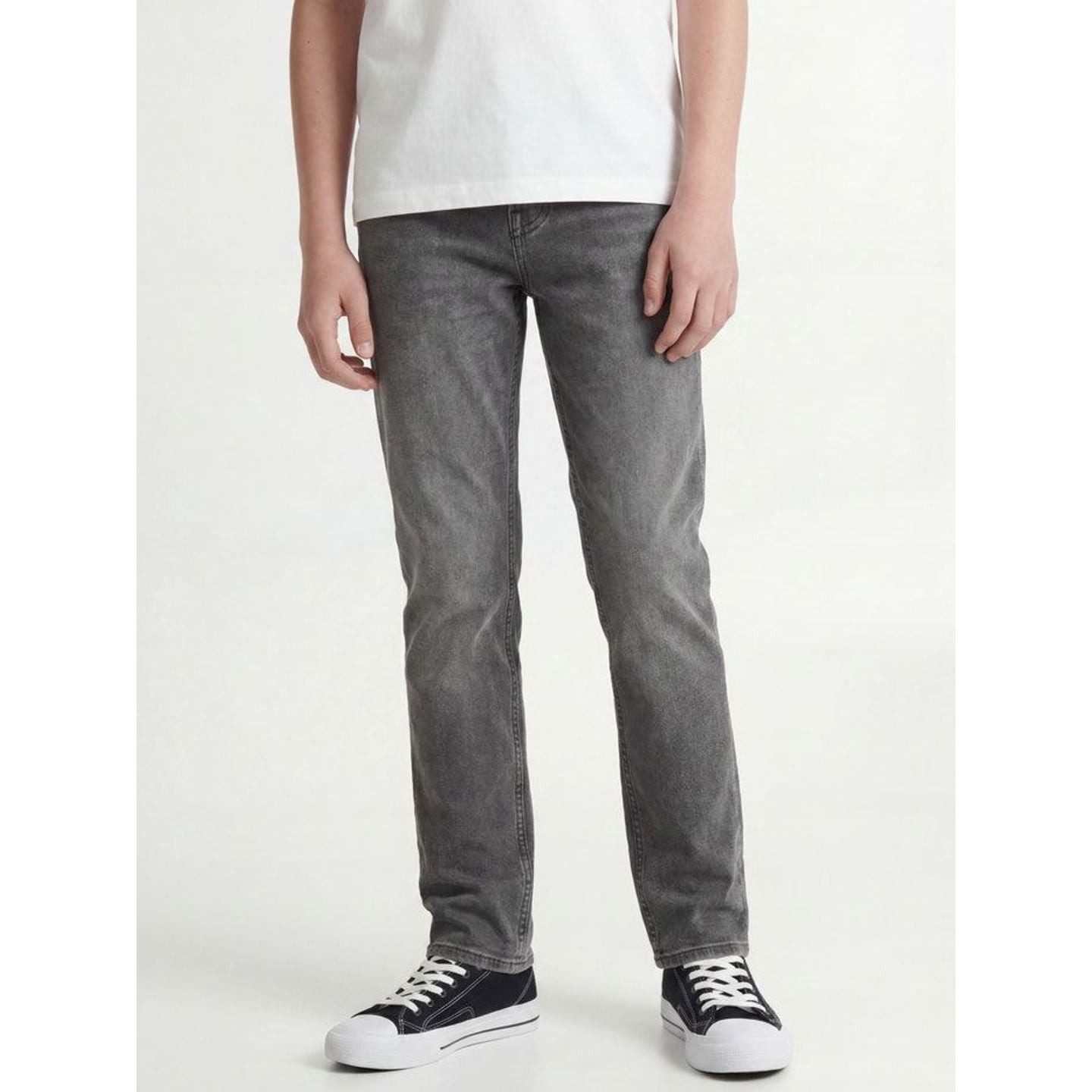Garçon assis portant un jean 2011501 JACK & JONES JUNIOR, mettant en avant la souplesse et le confor