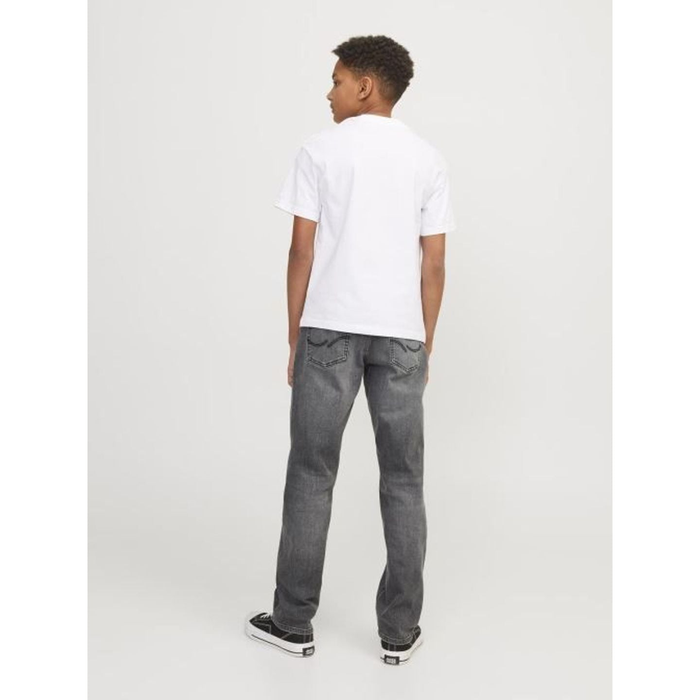 Image lifestyle : un garçon portant un jean 2011501 JACK & JONES JUNIOR, adossé à un mur, vue de fac