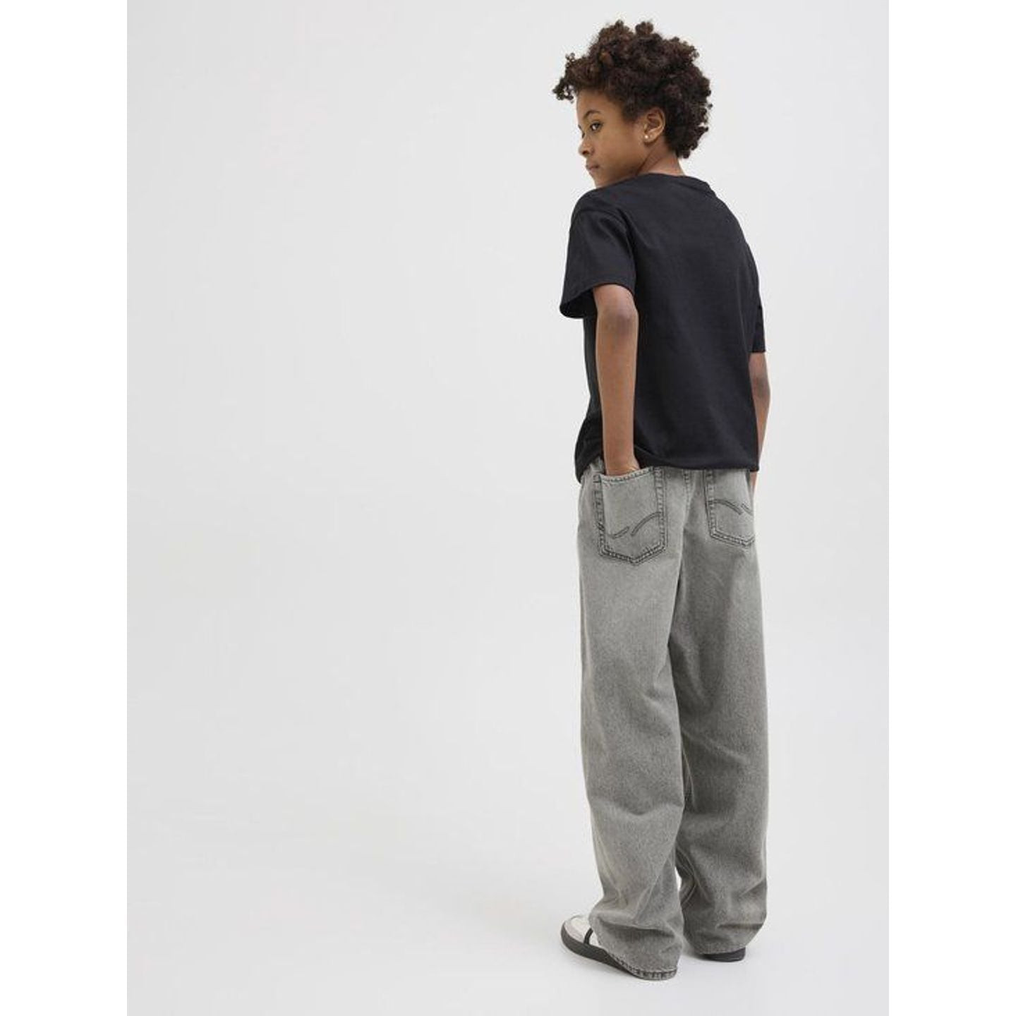 Garçon marchant en jean denim rigide Jack & Jones Junior, vue de face.