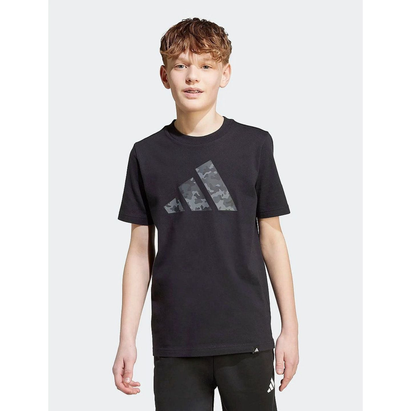 Adidas J Camo T lifestyle - vue latérale d'un mannequin junior, coupe régulière et manches courtes.