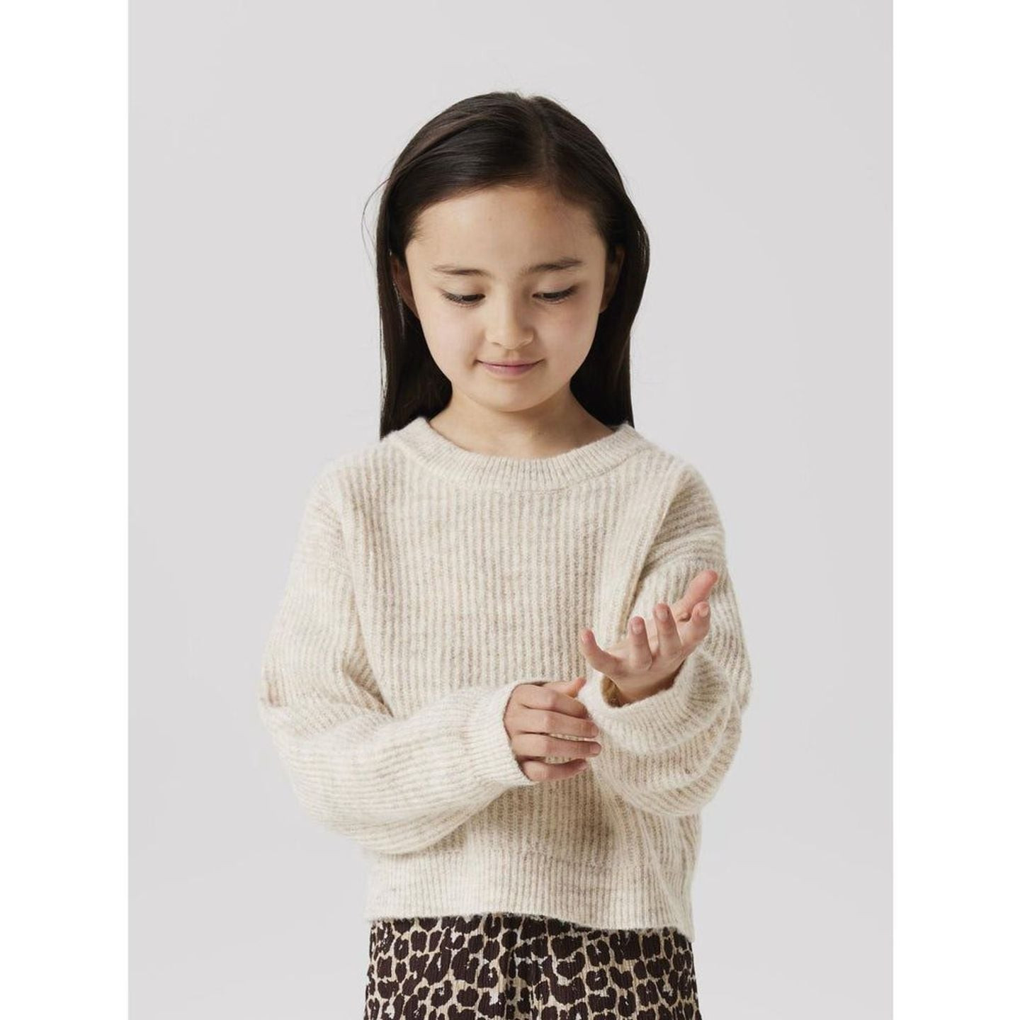 Enfant portant le pull tricoté cropped beige clair Name It 2071526, montrant les détails du tricot.