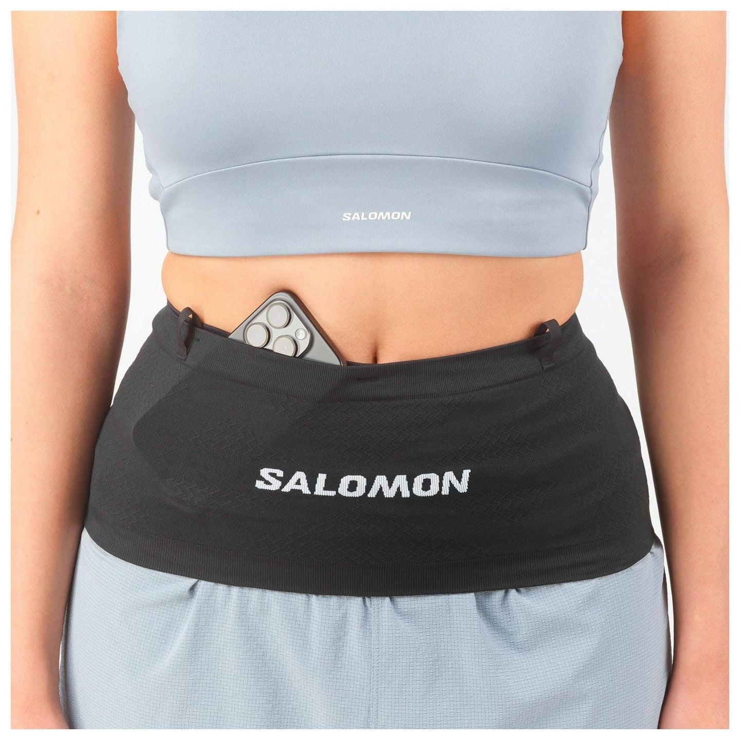 Image lifestyle d'un coureur avec la ceinture Salomon ADV Skin Seamless 2071407 en forêt, démontrant