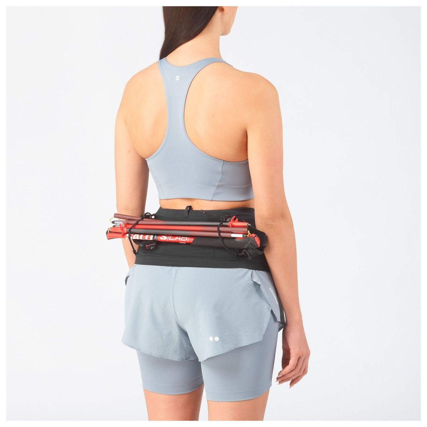 Traileur portant la ceinture Salomon ADV Skin Seamless Belt 2071407 avec bâtons, montrant les passan