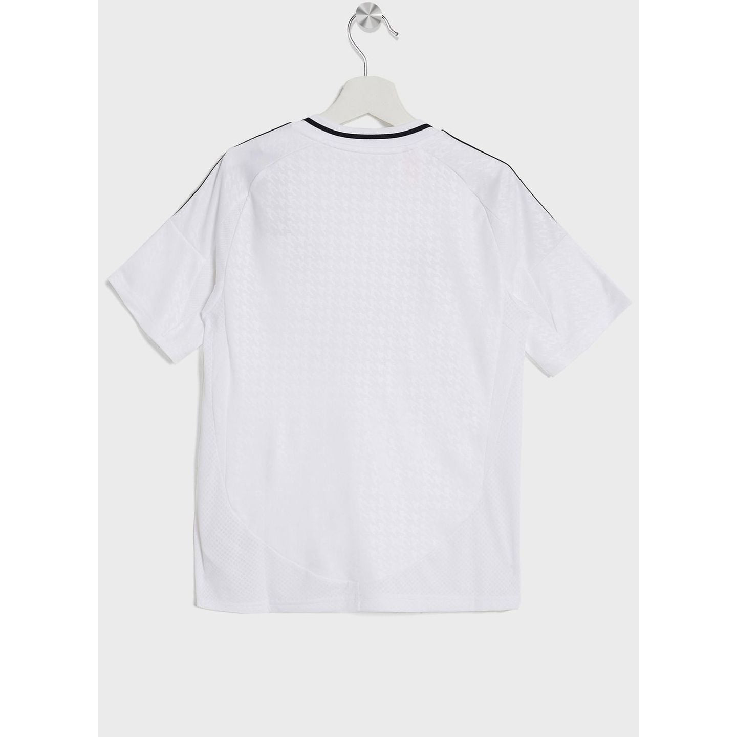 Vue latérale du maillot junior Real Madrid : motif pied-de-poule sur les manches, étiquette AEROREAD