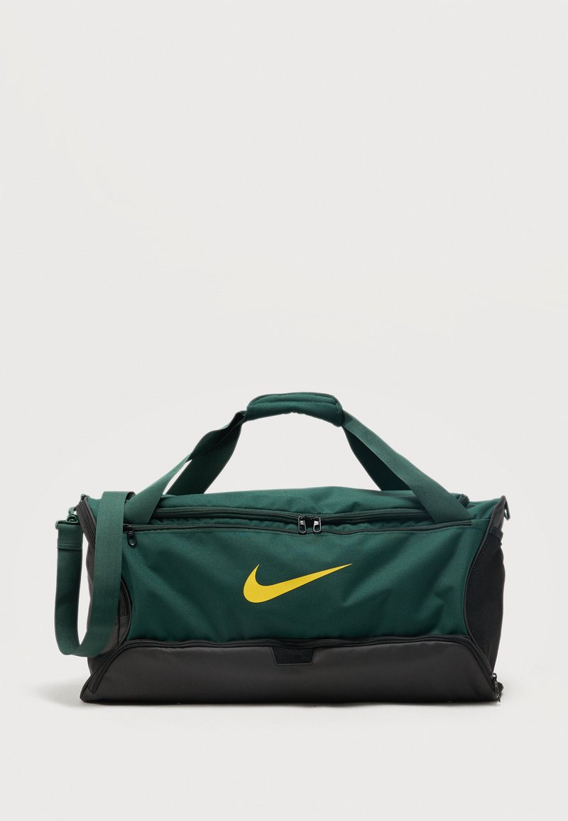 Nike Brasil Academy duffel bag in dark green with yellow swoosh and black reinforced base, shown on 