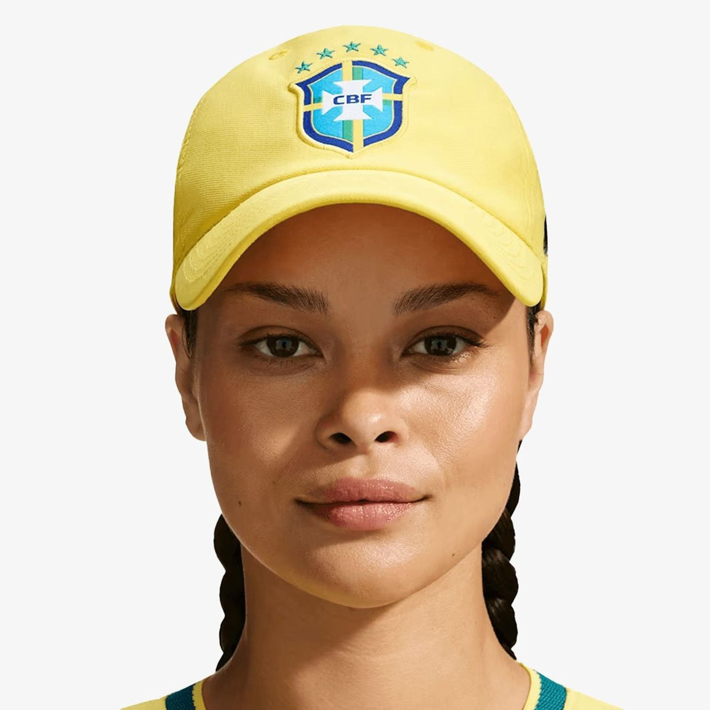 Modèle portant la casquette Nike CBF Brésil Club jaune, vue de face, avec des cheveux tressés