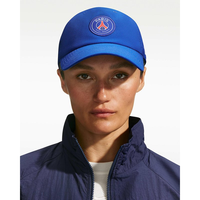 Woman wearing blue Nike PSG Club Cap with embroidered Paris Saint-Germain crest