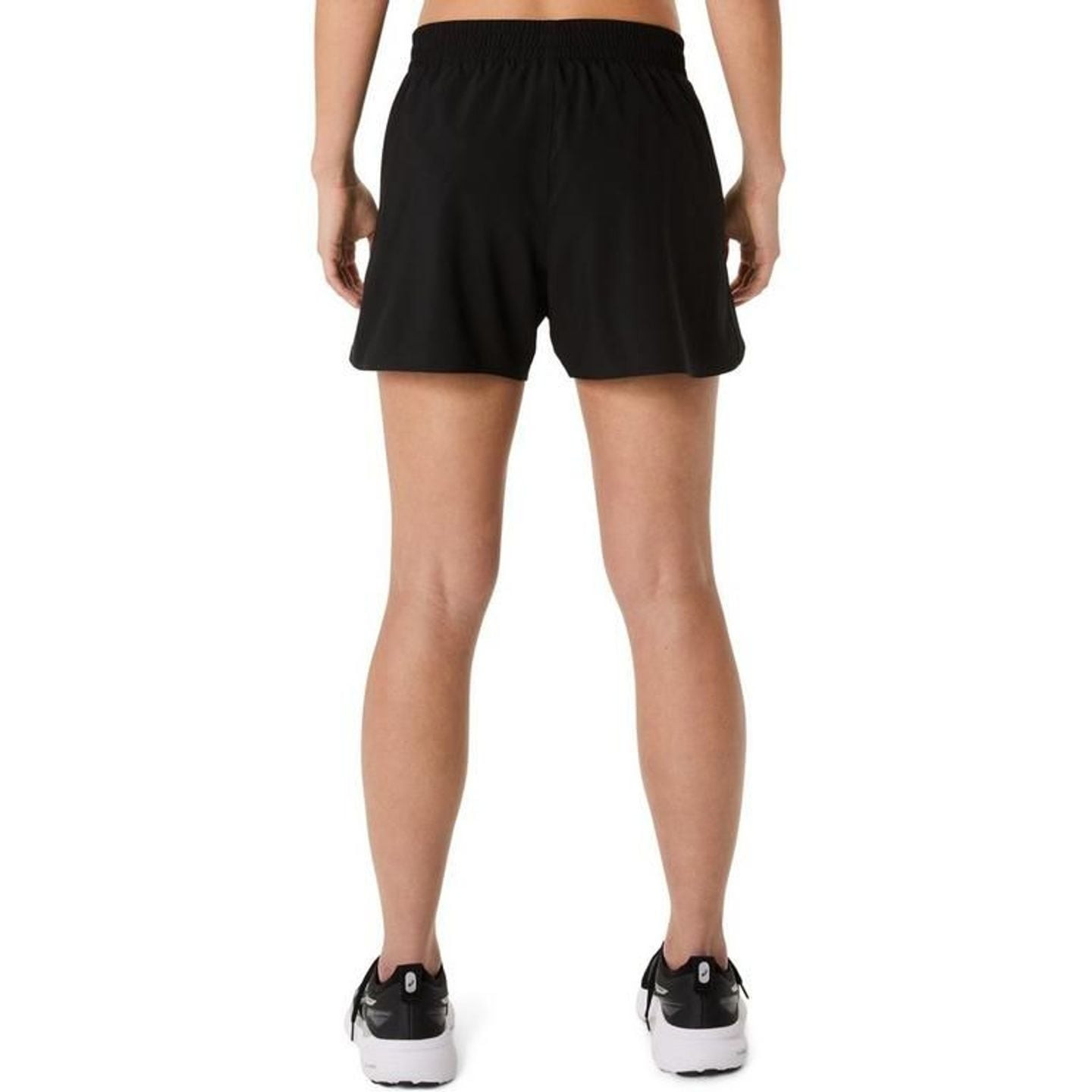 Asics Short De Running Core 4In Femme Léger Respirant Séchage Rapide, coureuse en pleine action.