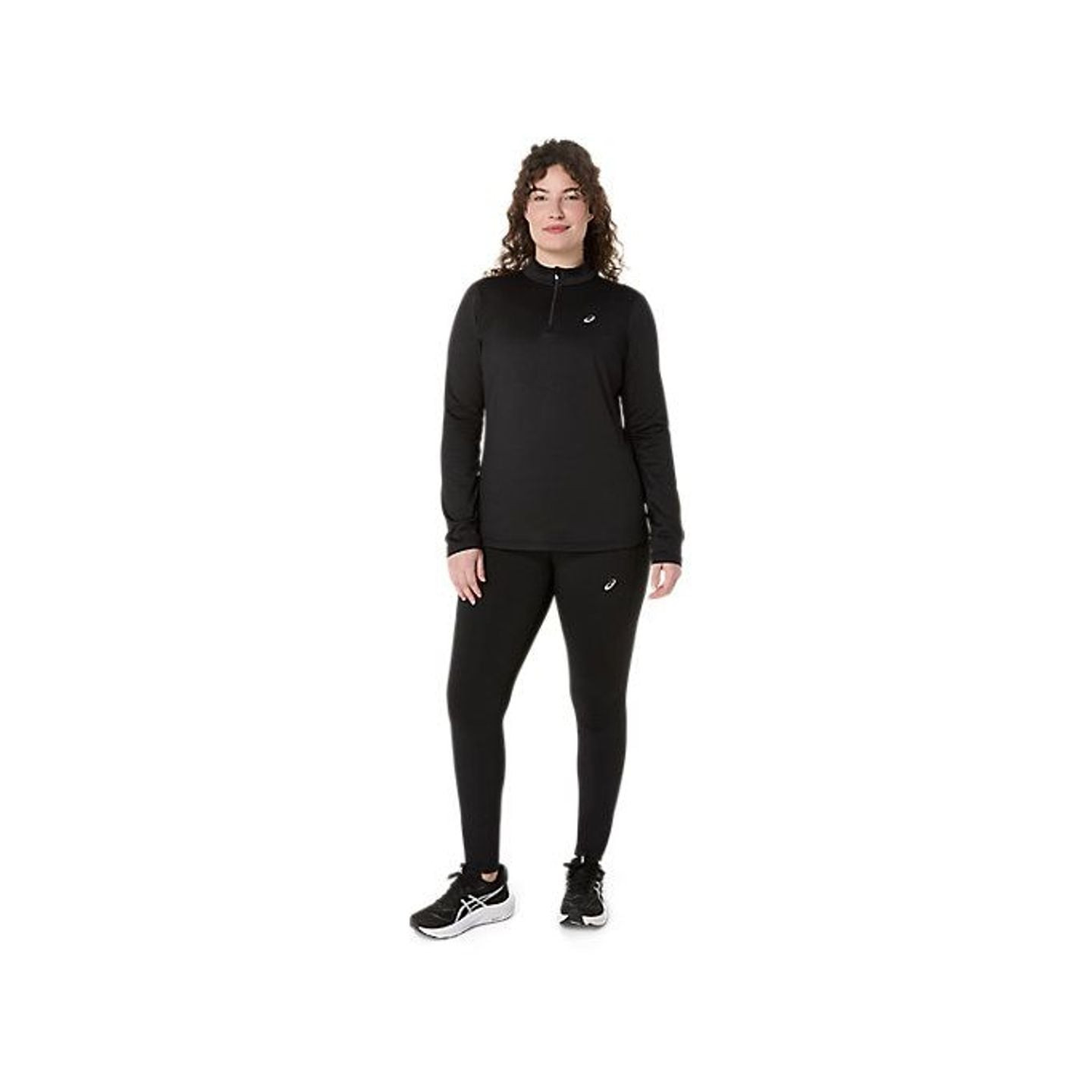 Vue de face d'une femme portant un haut ASICS Core LS 1/2 Zip Winter noir, legging et chaussures de 