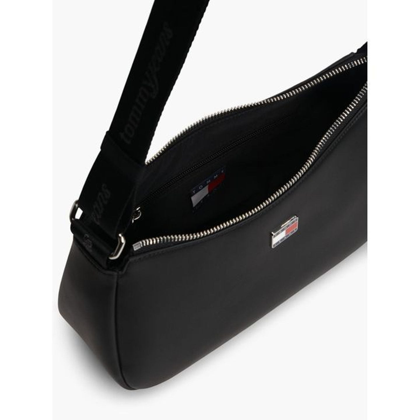 Gros plan sur l’intérieur du sac noir : fermeture zippée argentée, sangle logo et poche intérieure