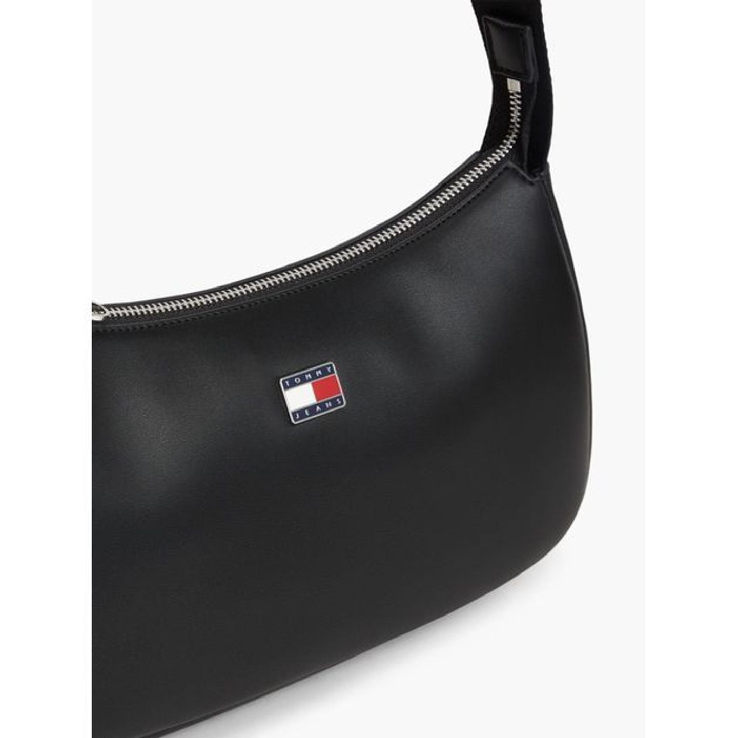 Détail du similicuir noir lisse avec logo drapeau Tommy Jeans et fermeture éclair argentée