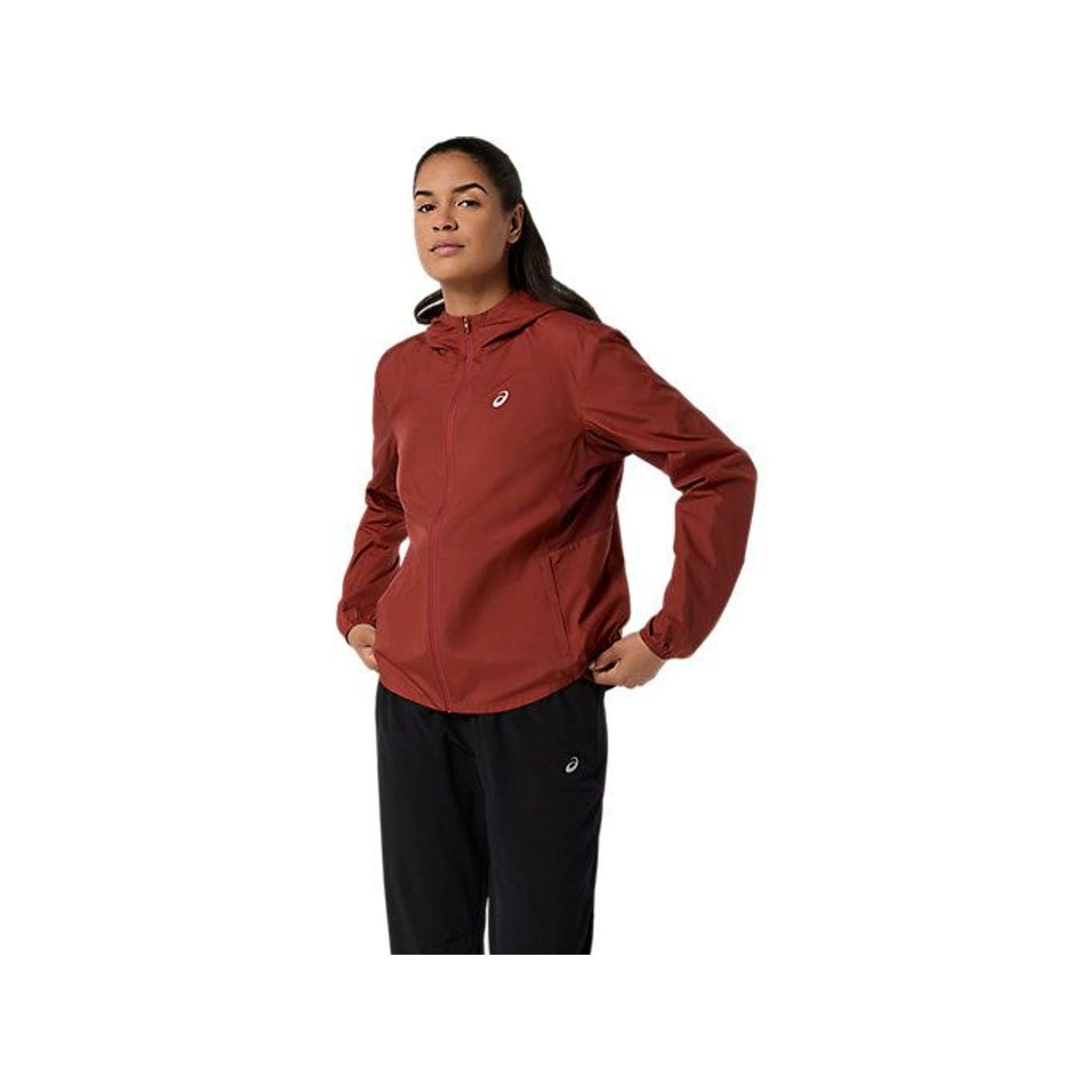 Coureuse portant l'Asics Veste De Running Déperlante Core Femme À Capuche Réglable en extérieur.