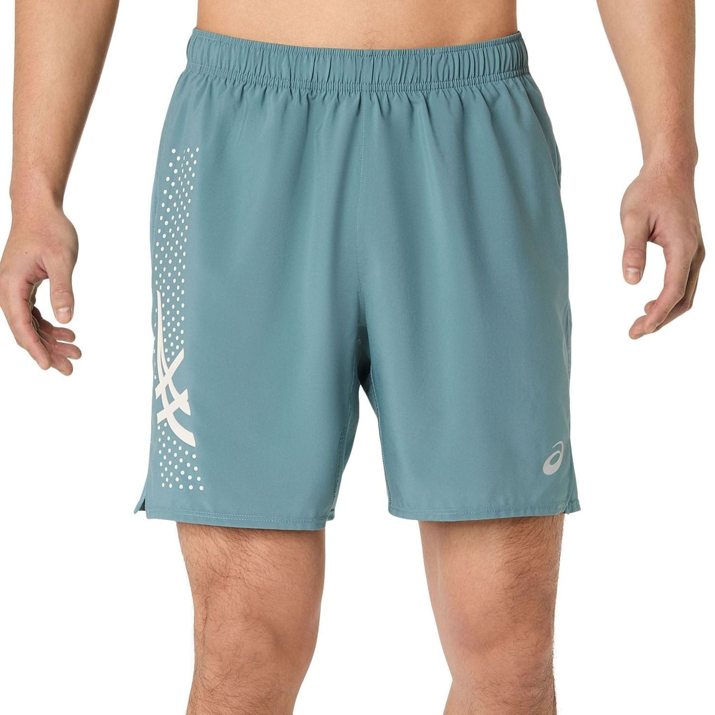 Coureur homme portant un short ASICS ICON 7IN sarcelle brumeuse sur fond de studio blanc
