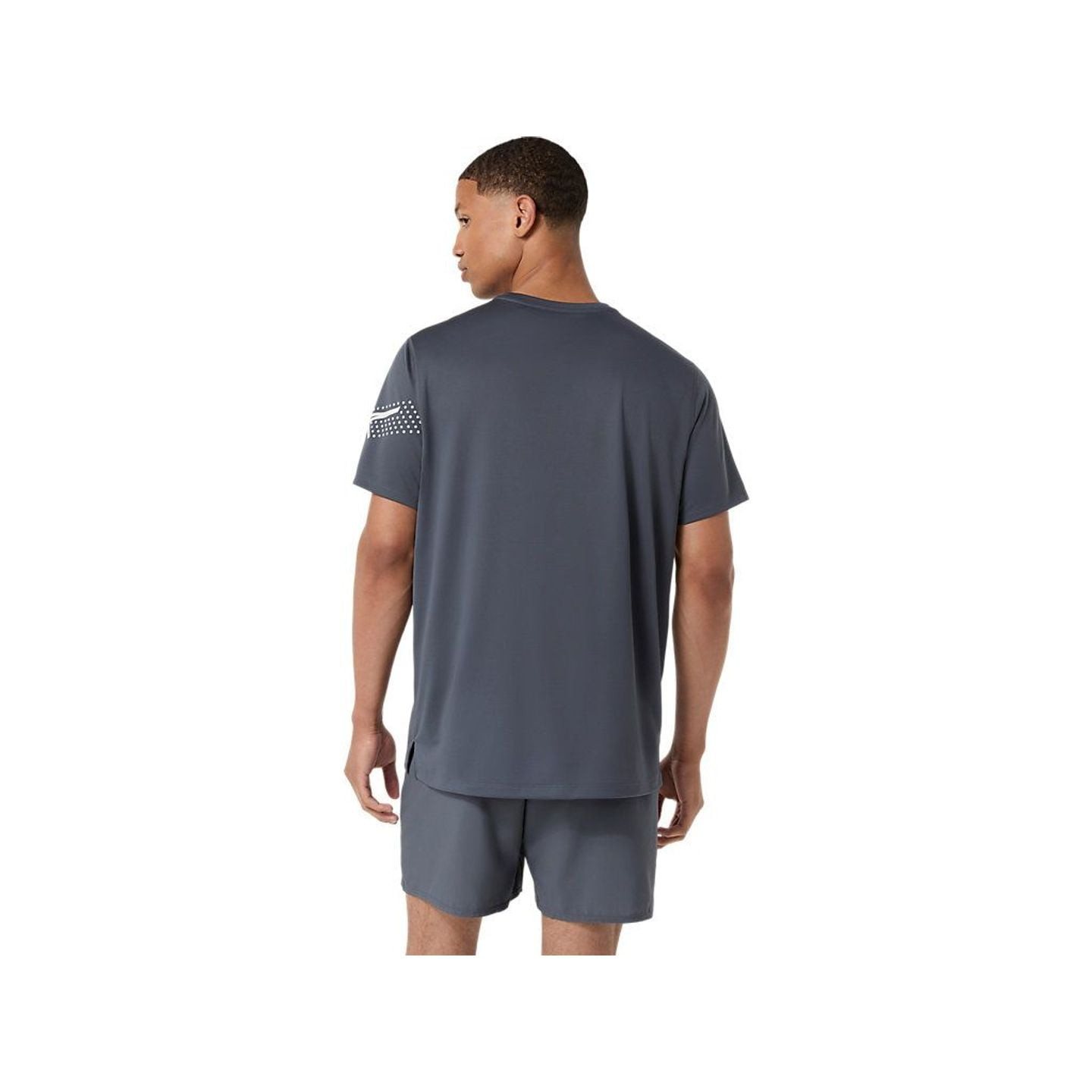 Vue arrière d'un homme portant le t-shirt de running gris ASICS ICON SS TOP, ourlet incurvé et fente