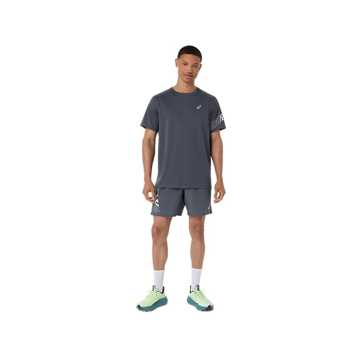 Vue en pied d'un homme portant le t-shirt ASICS ICON SS TOP gris, un short et des chaussures de runn