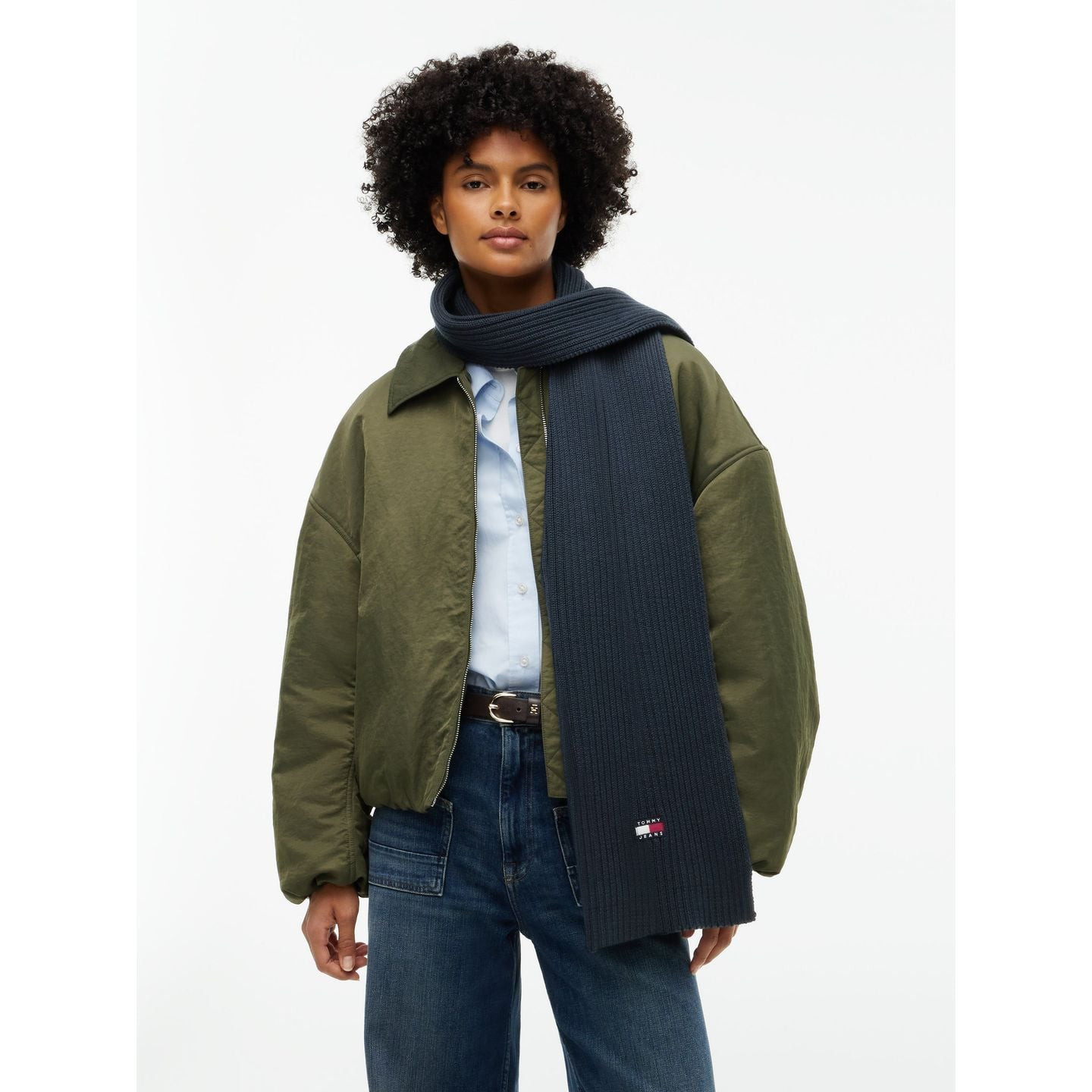 Modèle portant l’écharpe marine TJW Heritage Core enroulée autour du cou, veste olive et jean