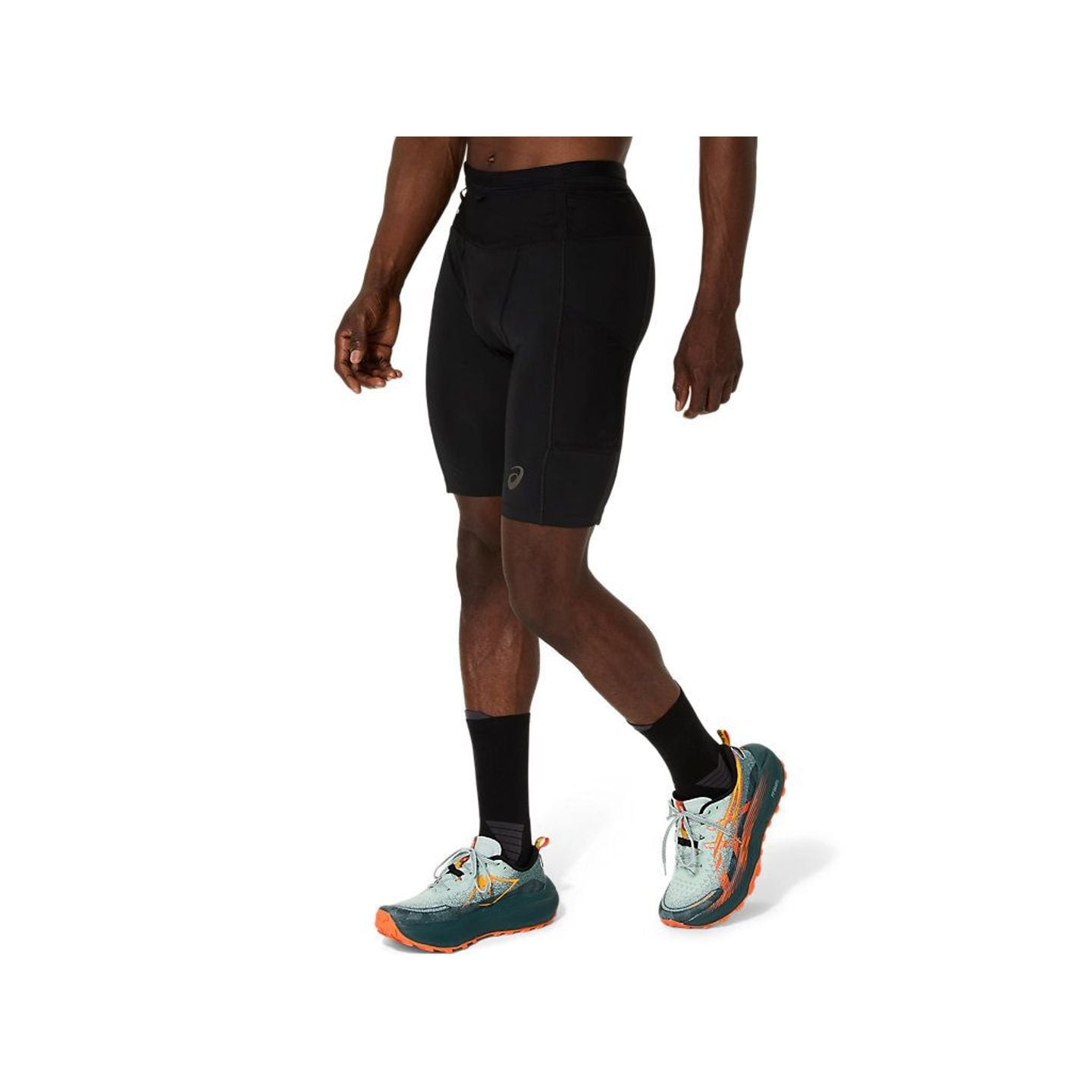 Coureur marchant en short de trail ASICS FUJITRAIL ELITE SPRINTER noir et chaussures de trail, vue d