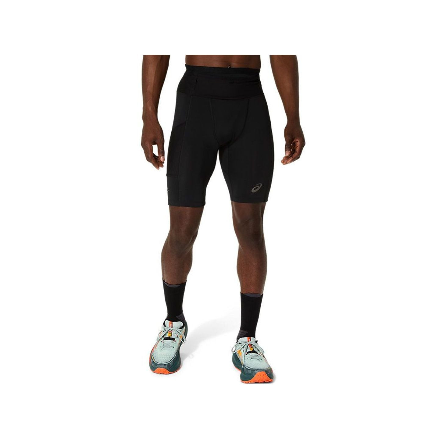 Vue de face d’un coureur portant le short de trail ASICS FUJITRAIL ELITE SPRINTER noir et des chauss
