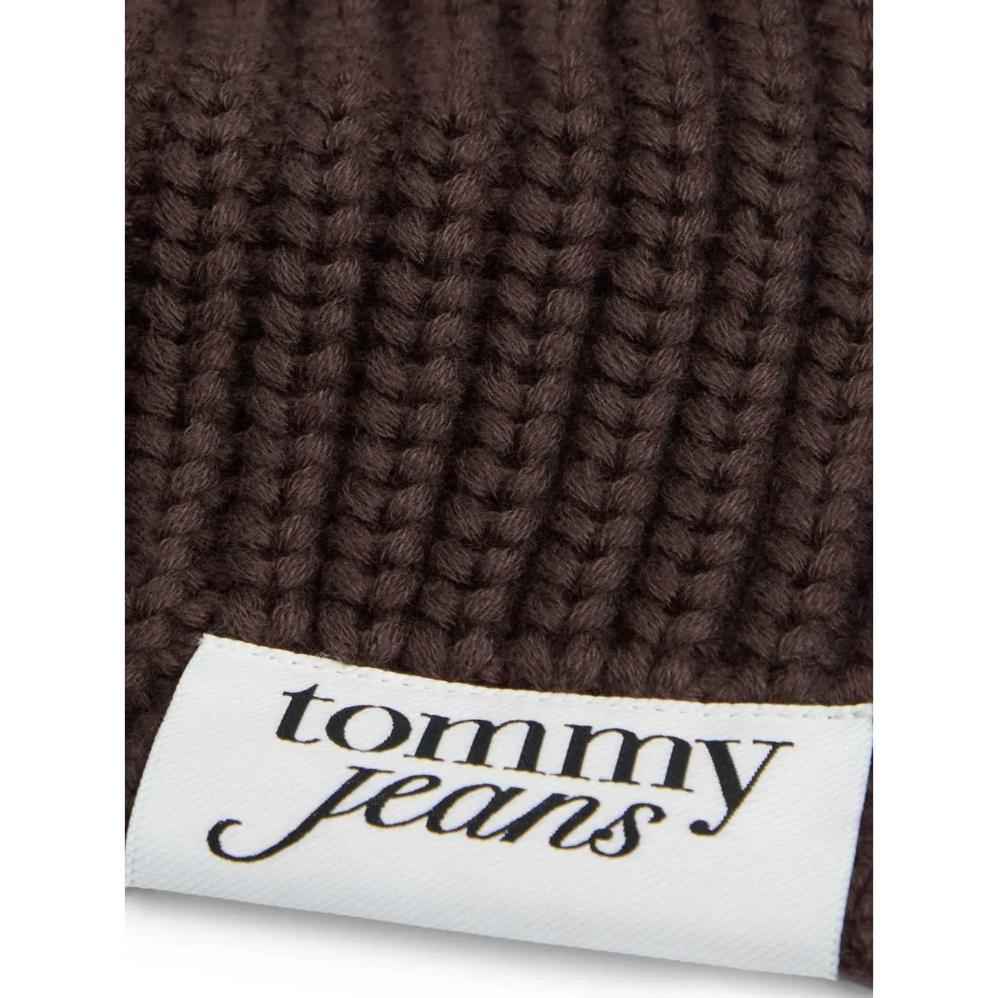 Gros plan macro sur la maille côtelée marron et l’étiquette blanche du logo Tommy Jeans sur l’écharp