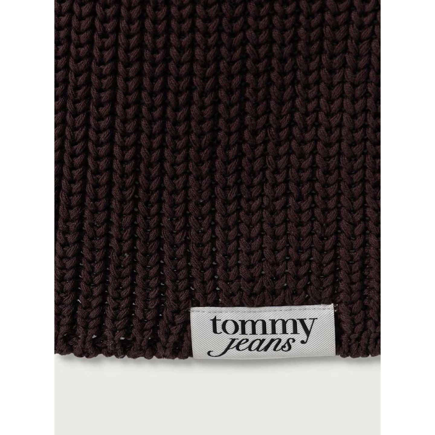 Gros plan sur les mailles épaisses marron de l'écharpe TJW Script et l'étiquette blanche Tommy Jeans