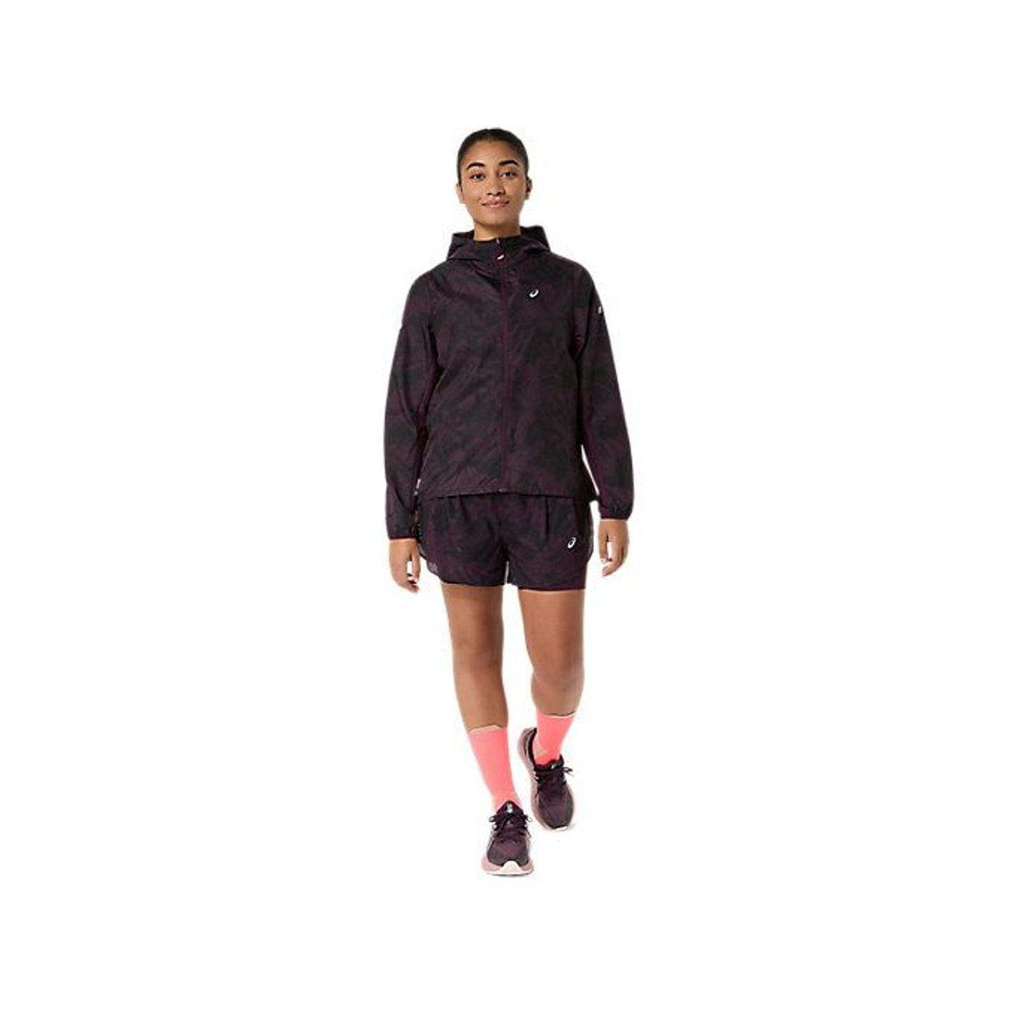 Coureuse marchant en tenue FUJITRAIL complète : veste packable, short, chaussettes roses et chaussur
