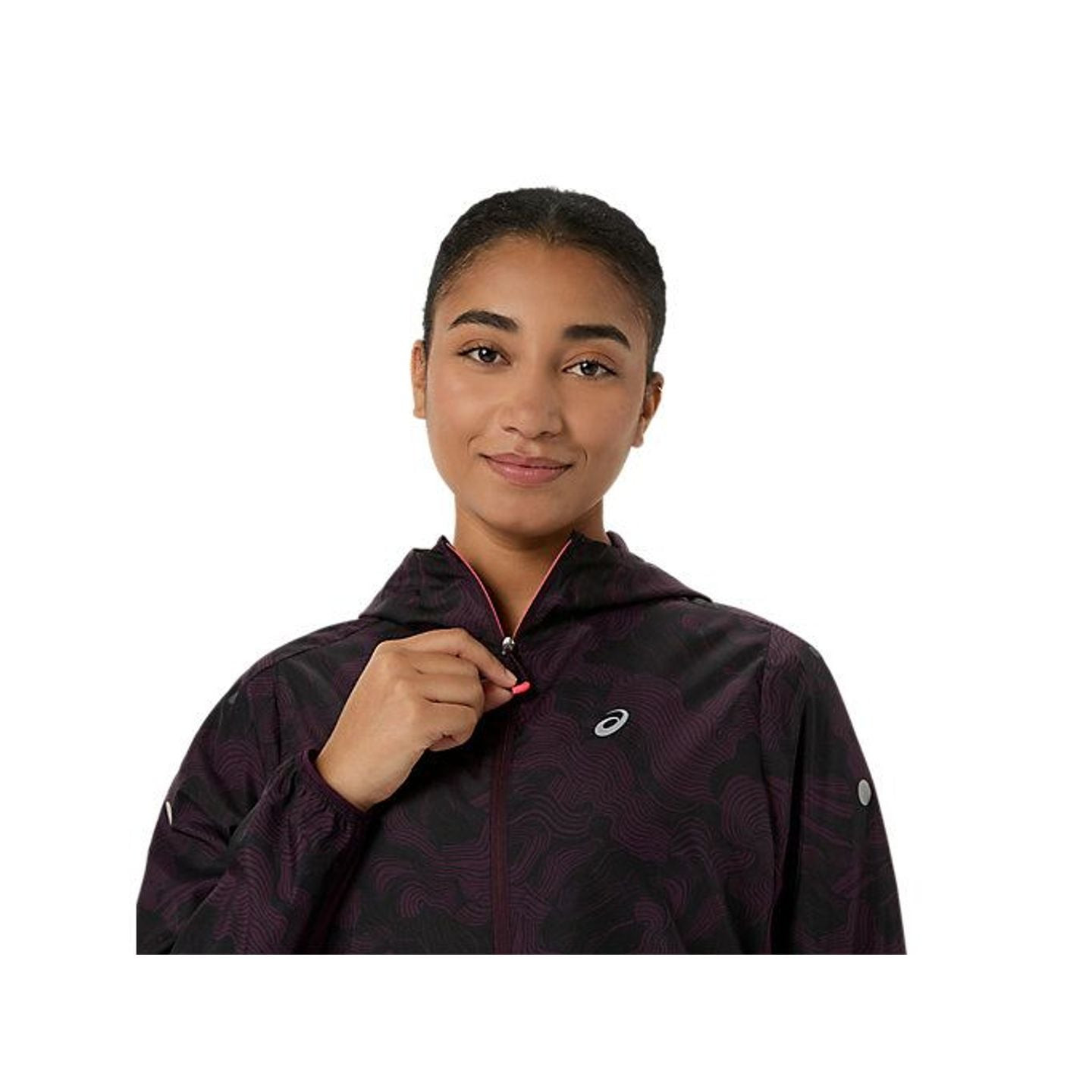 Coureuse zippant la veste packable FUJITRAIL, montrant la fermeture intégrale, la capuche et le col 