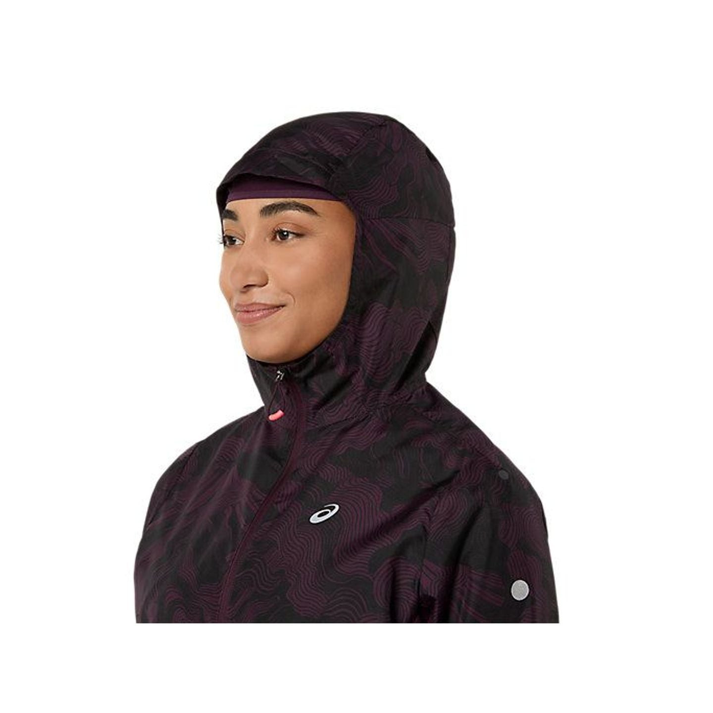 Coureuse portant la veste FUJITRAIL, capuche élastiquée relevée et cordon serré pour se protéger des