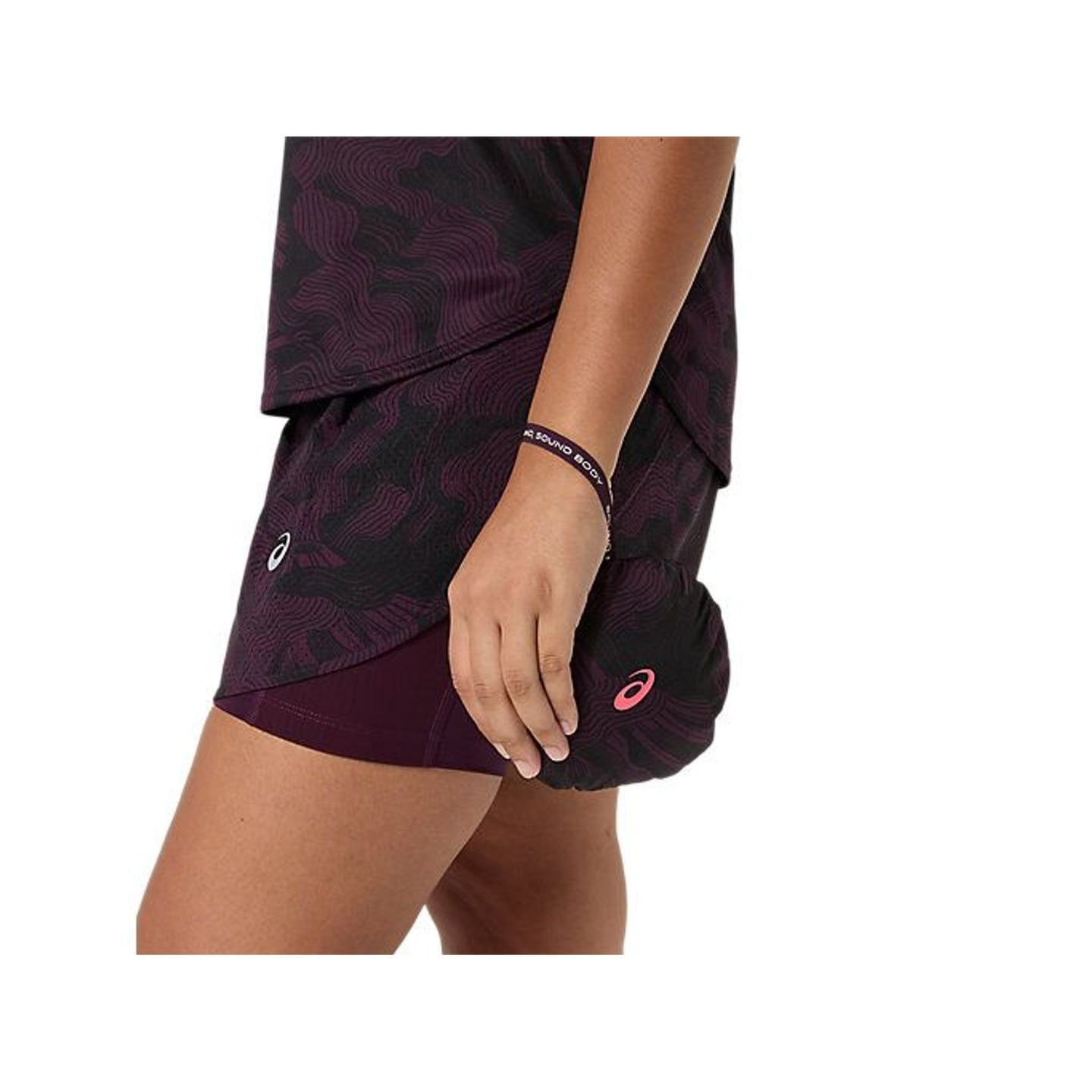 La veste FUJITRAIL rangée dans sa poche arrière, tenue d'une main, montrant sa taille compacte.