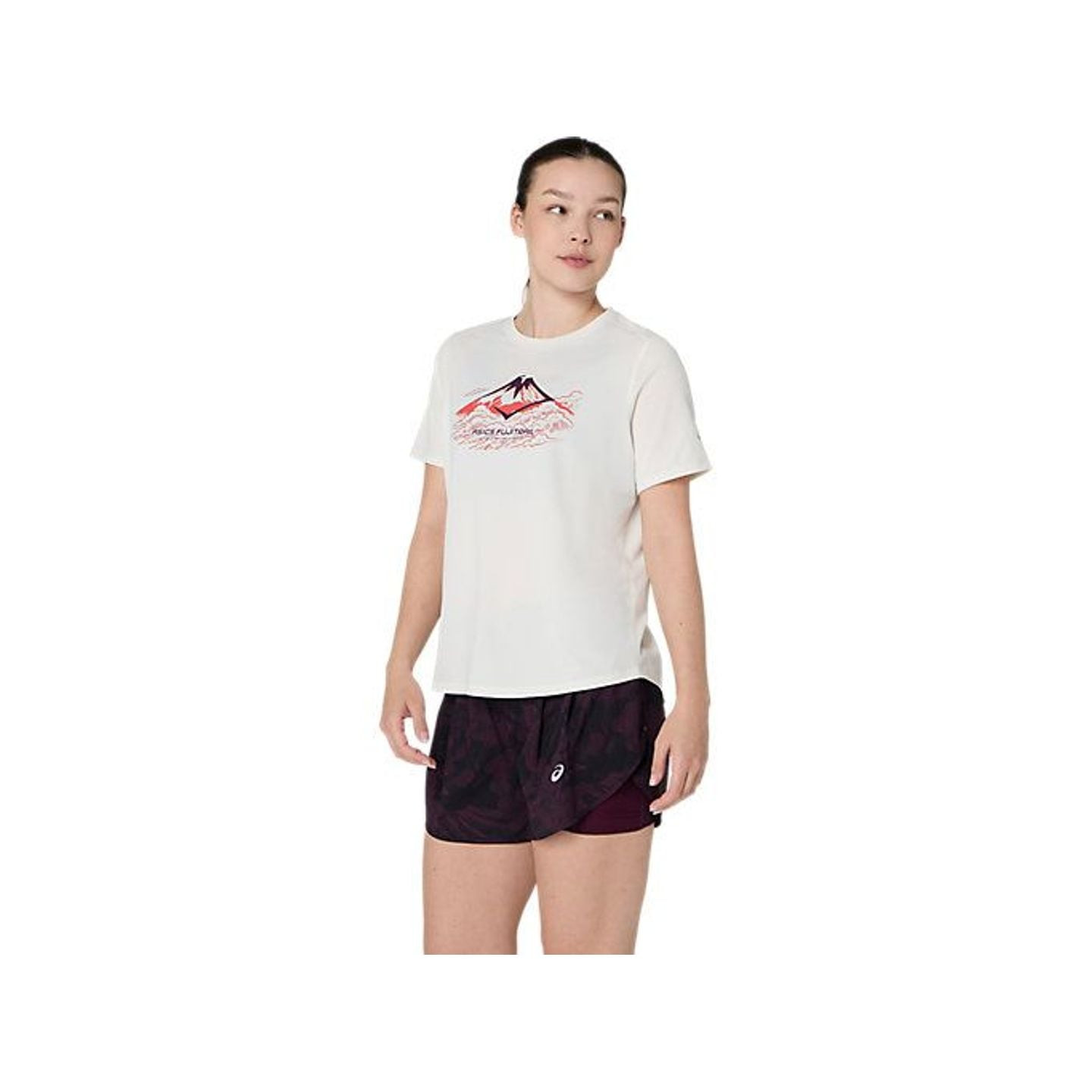 Traileuse portant le top Asics Top À Manches Courtes De Trail Running Fujitrail Logo Femme en pleine