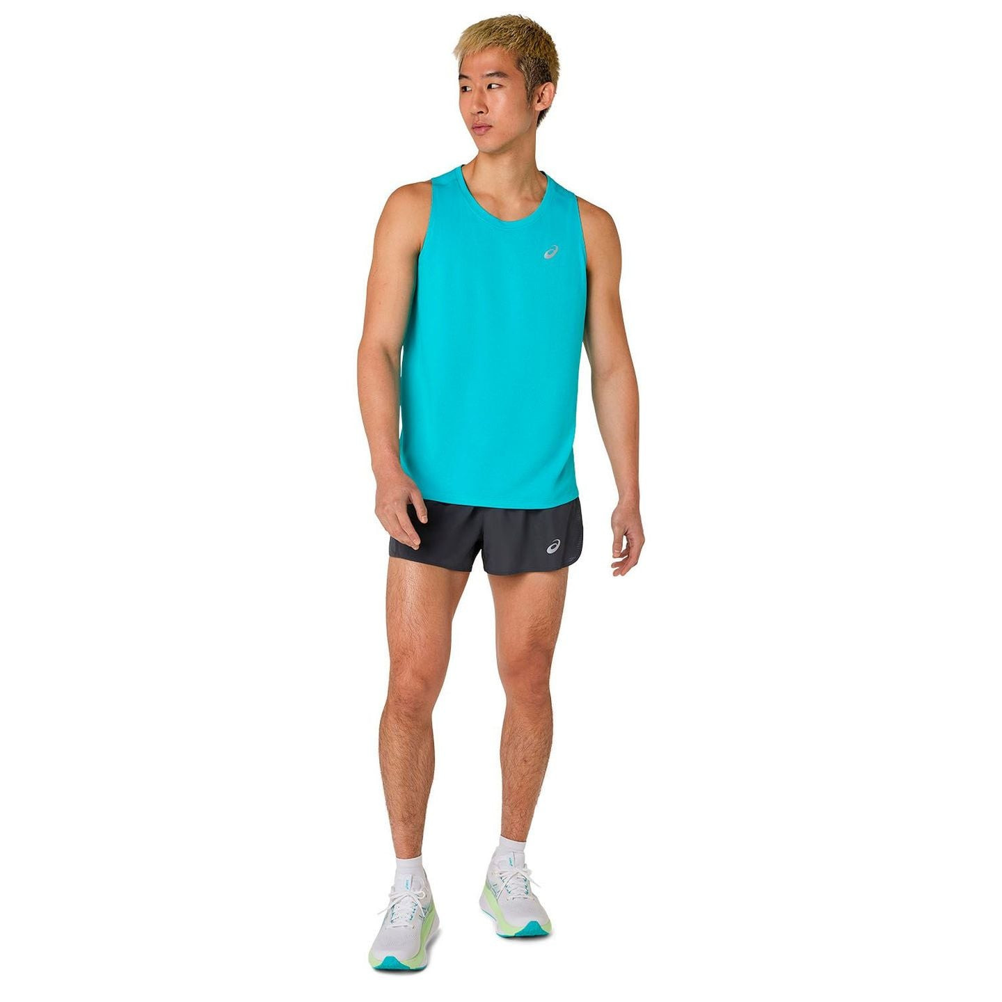 Vue en pied d’un coureur en débardeur ASICS Core turquoise, short gris, chaussettes blanches et chau
