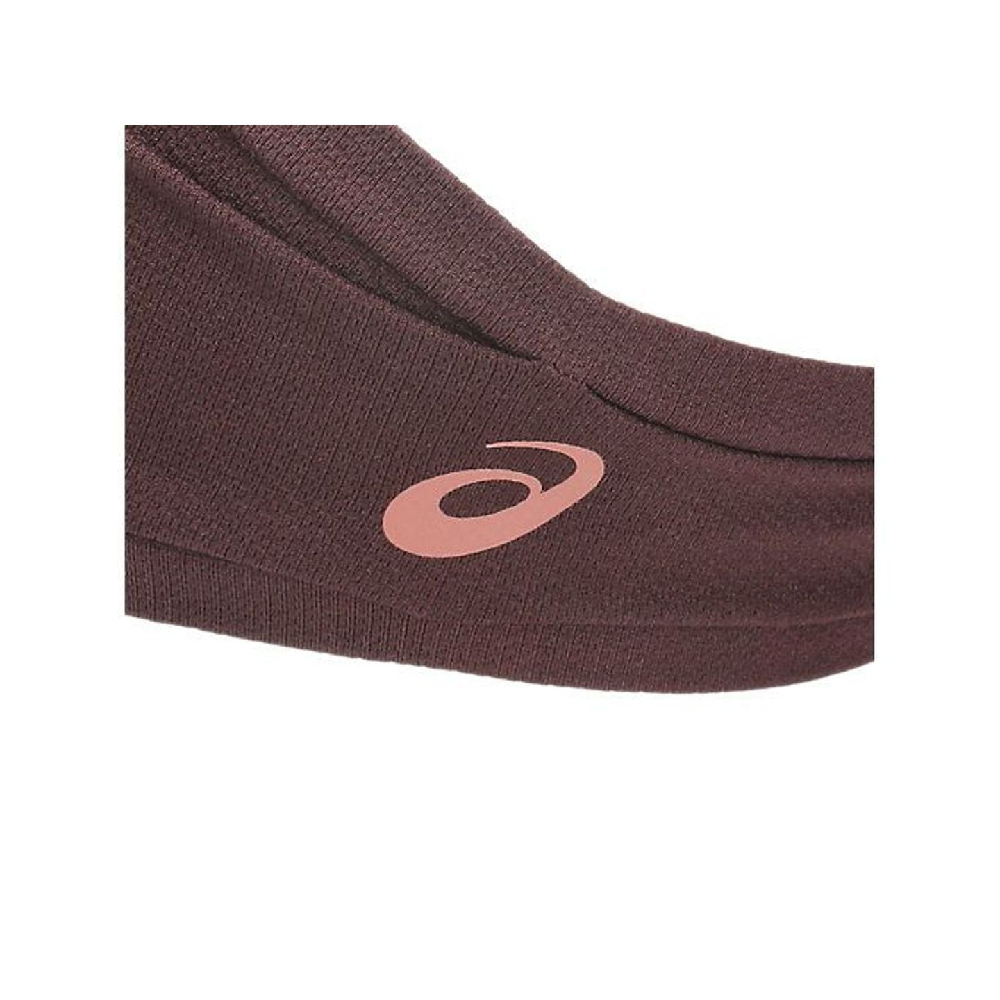 Gros plan du logo ASICS rose doré sur le tissu bordeaux du bandeau PERFORMANCE HEAD BAND
