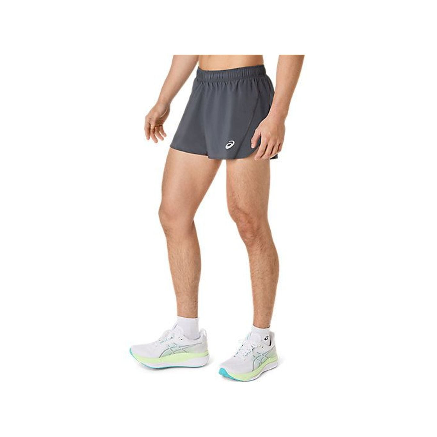 Coureur marchant de profil, short ASICS Core Split gris foncé fendu sur le côté pour une liberté de 