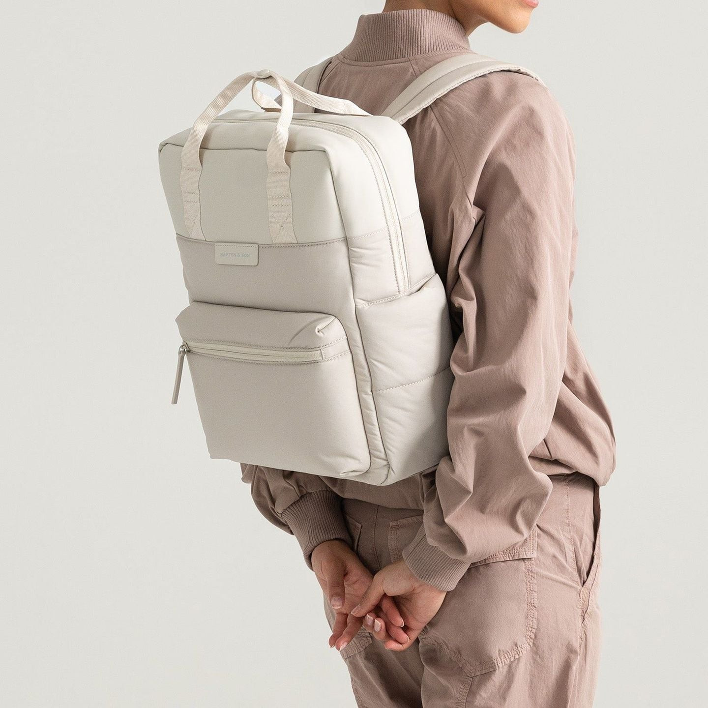 Modèle portant le sac à dos Kapten & Son Bergen Cloud sable sur le dos, bretelles rembourrées et sil