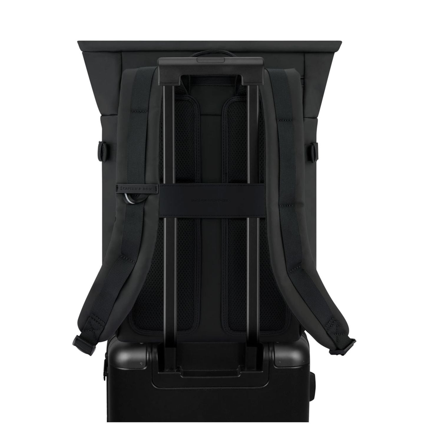 Sac à dos HERLSINKI ALL BLACK fixé sur une valise à roulettes via sa sangle passe-valise arrière, vu