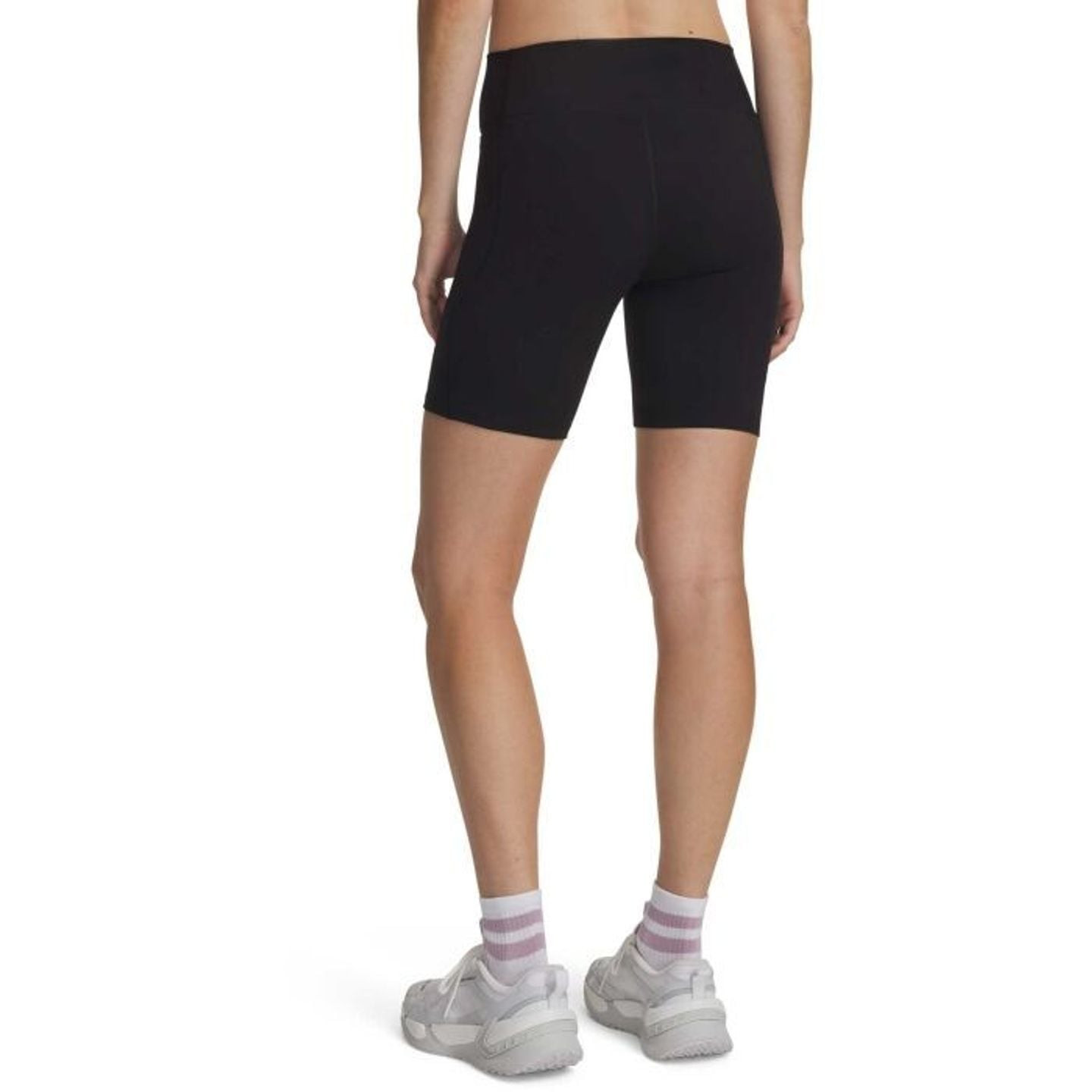 Vue de dos d'un mannequin en short cycliste Under Armour Motion noir, chaussettes et baskets blanche