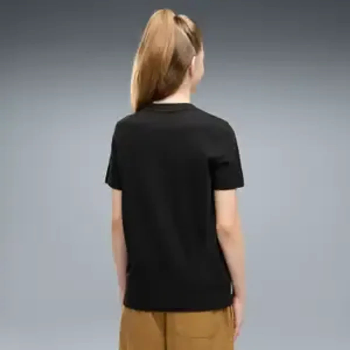 Vue de dos d'une fille portant le t-shirt noir PUMA ESS Script Glitter G, dos uni et pantalon marron
