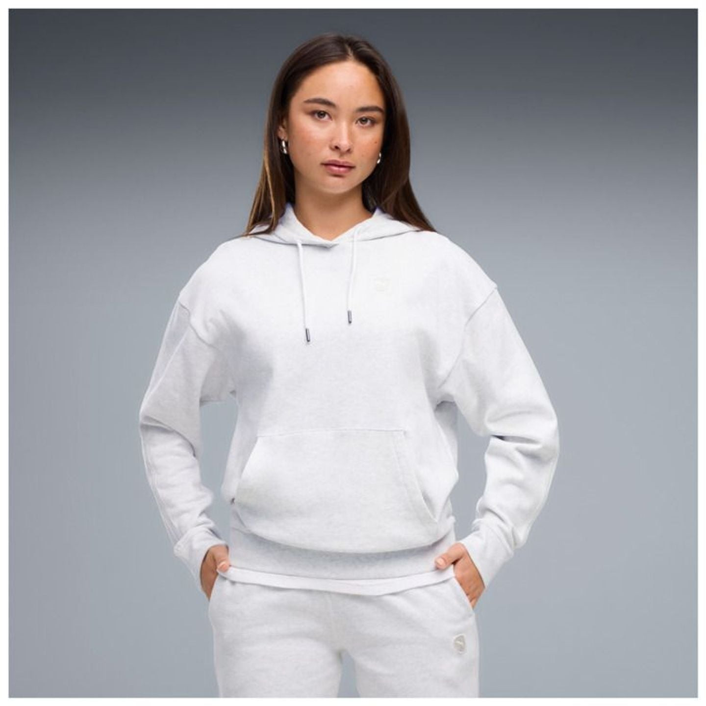 Mannequin en sweat à capuche PUMA ESS Elevated Comfort FL blanc et jogging assorti, mains dans les p