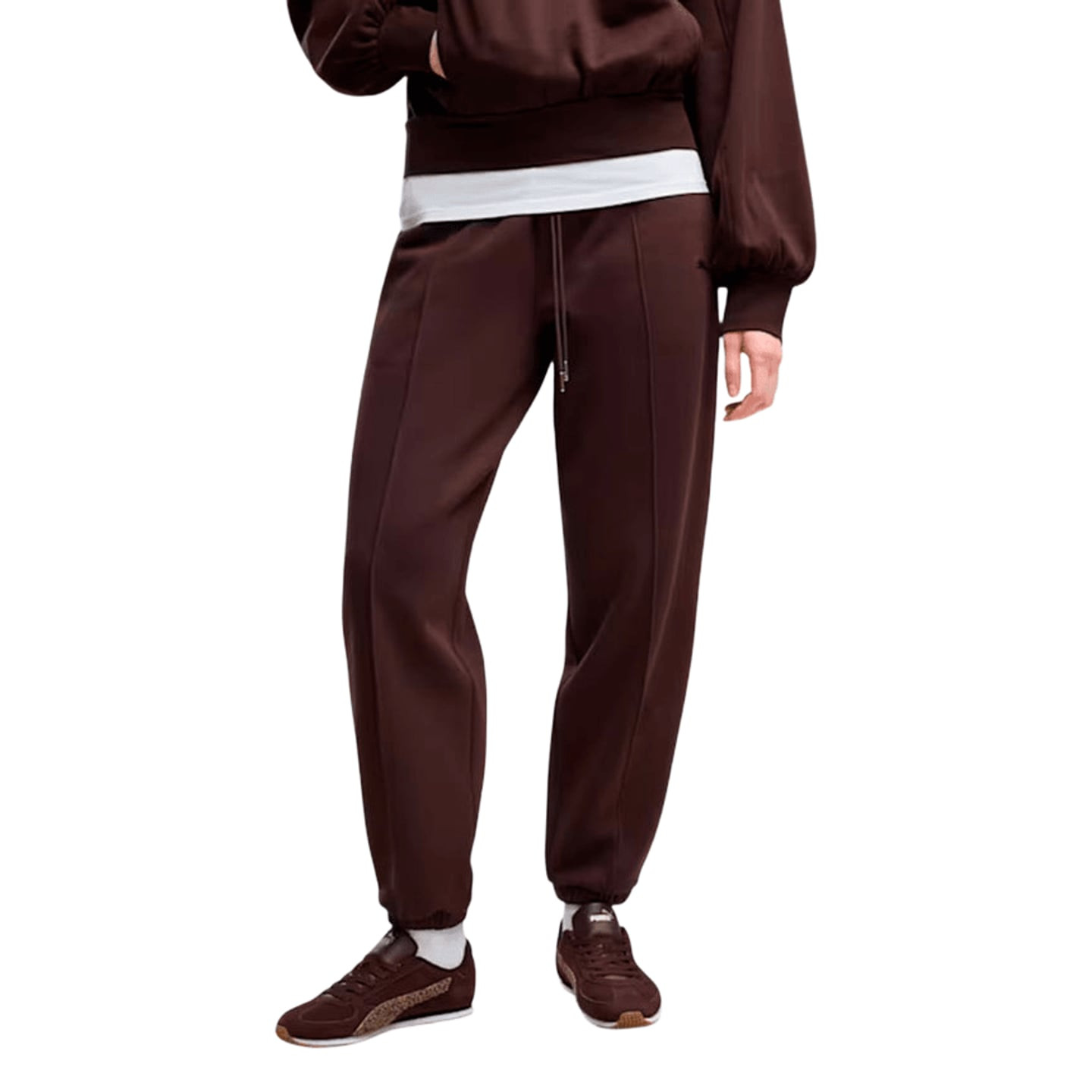 Femme portant le pantalon PUMA HER Comfort Pants FL marron avec taille à cordon de serrage, poignets