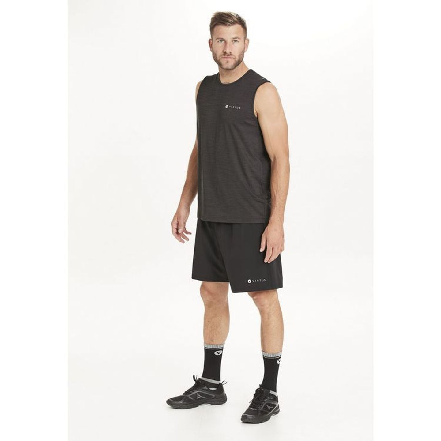 Modèle homme portant le short VIRTUS Forzer M noir et un débardeur noir, vue de face en pied
