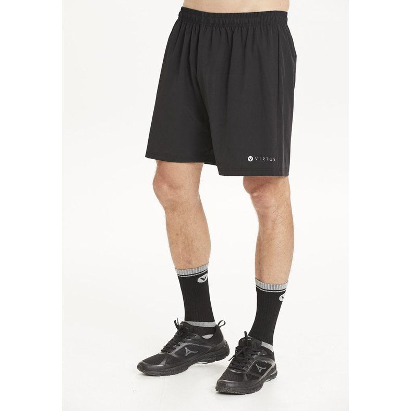 Homme portant un short noir VIRTUS Forzer M avec chaussettes noires et chaussures de running, vue li
