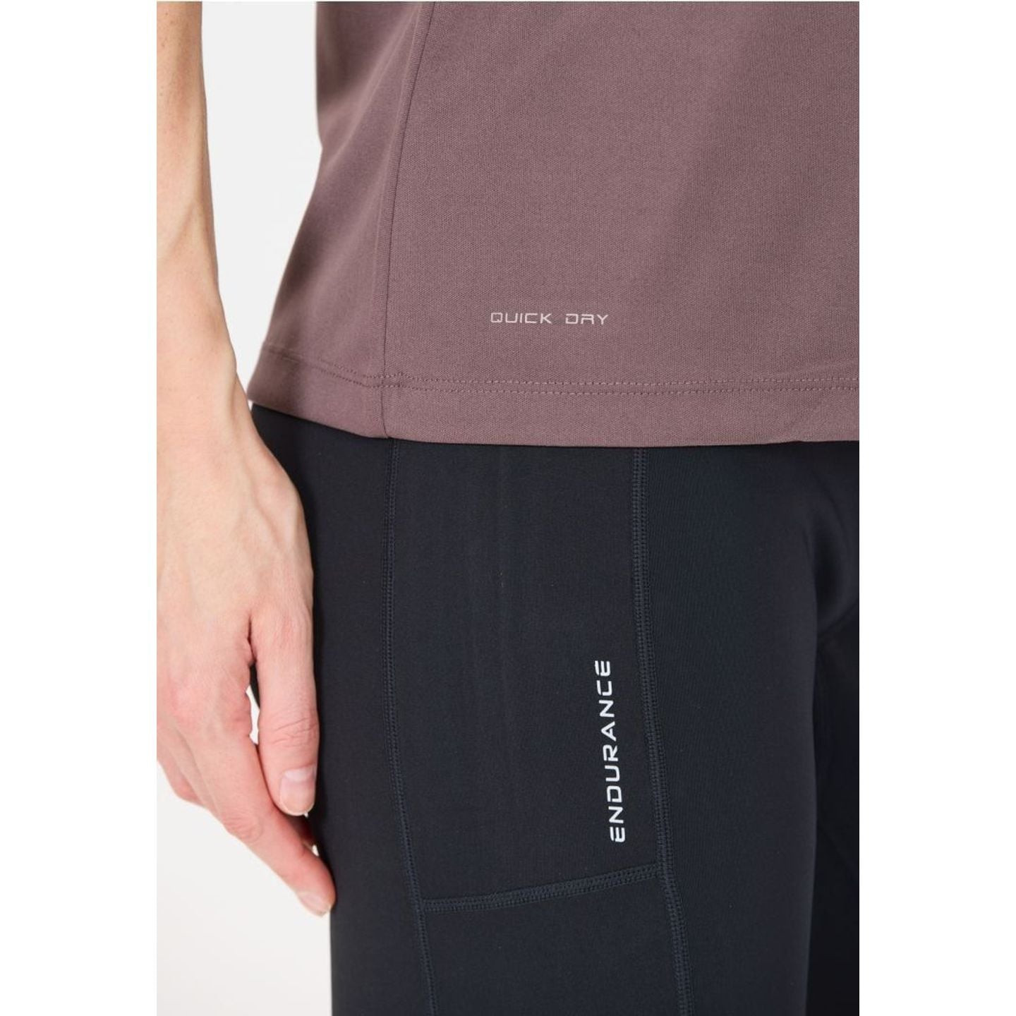 Gros plan sur l'ourlet du t-shirt KEILY V2 avec impression Quick Dry près d'un legging ENDURANCE noi