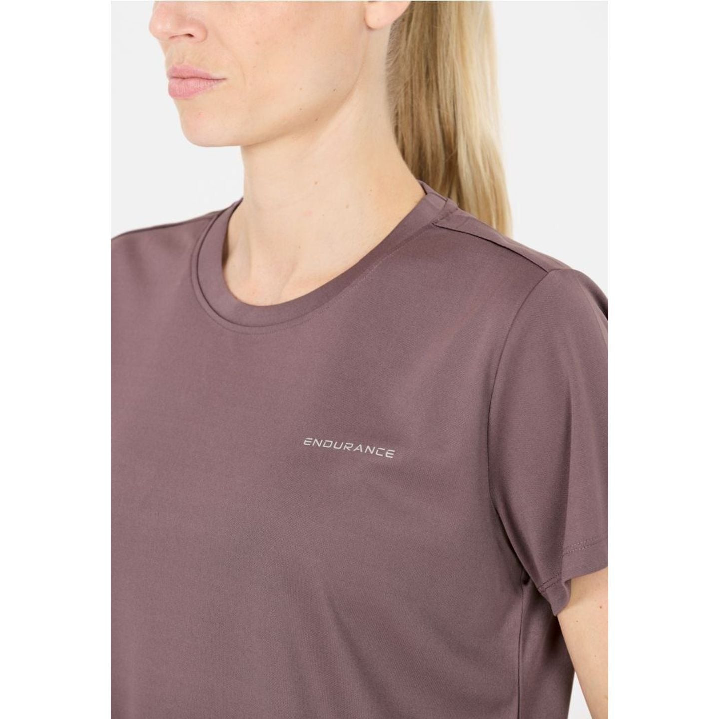 Gros plan d'une femme portant le t-shirt d'entraînement KEILY V2 mauve, montrant l'encolure et le lo