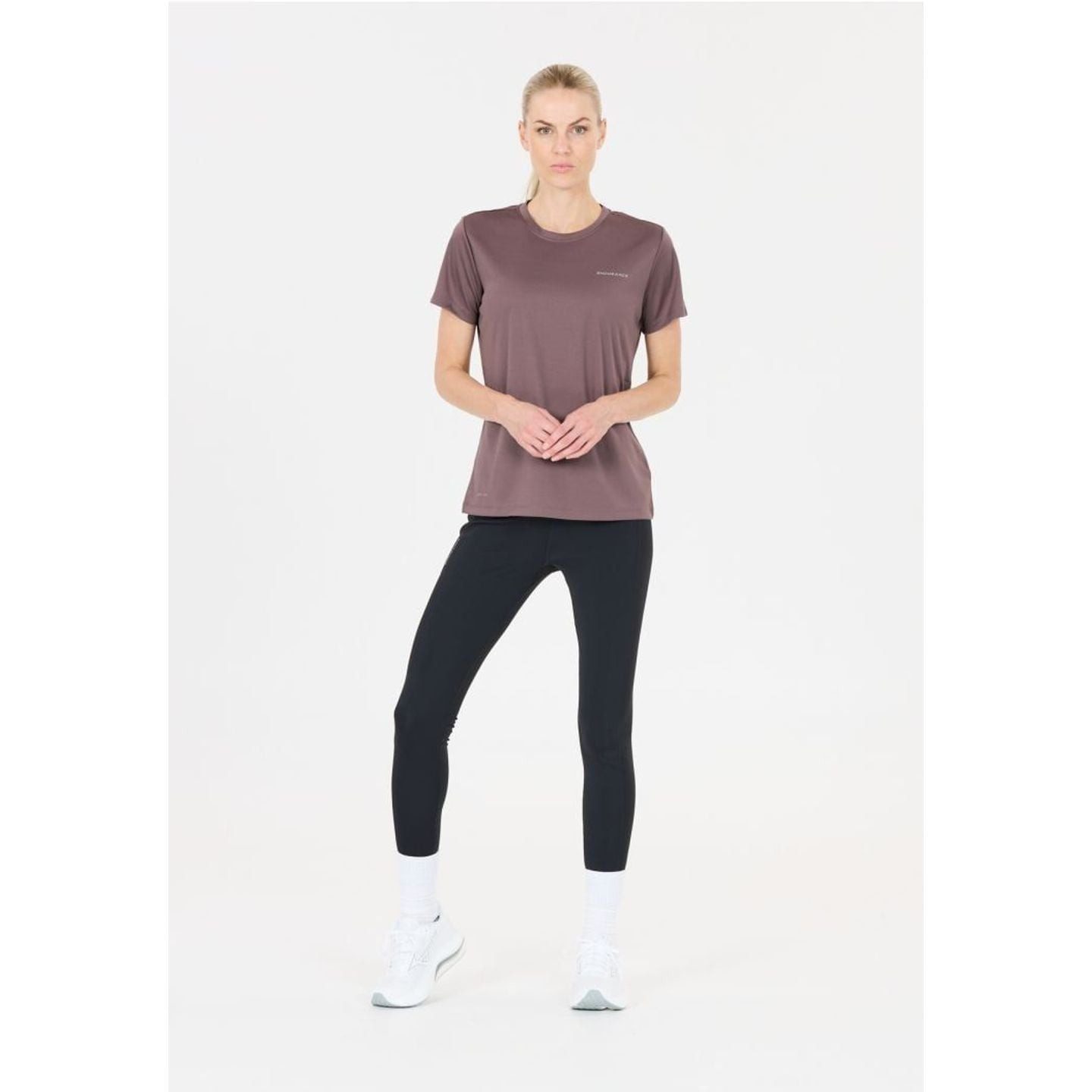 Mannequin portant le t-shirt KEILY V2 W S/S TEE mauve, leggings noirs et baskets blanches, vue de fa