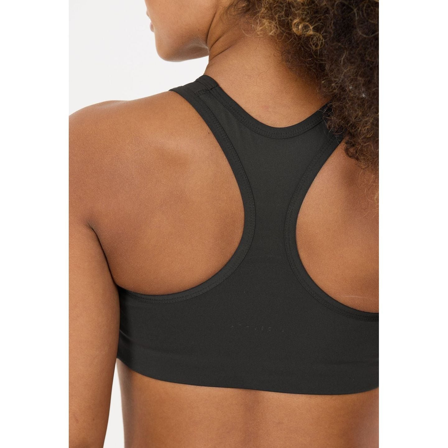 Gros plan des bretelles dos nageur de la brassière de sport noire Athlecia sur le dos d’un mannequin