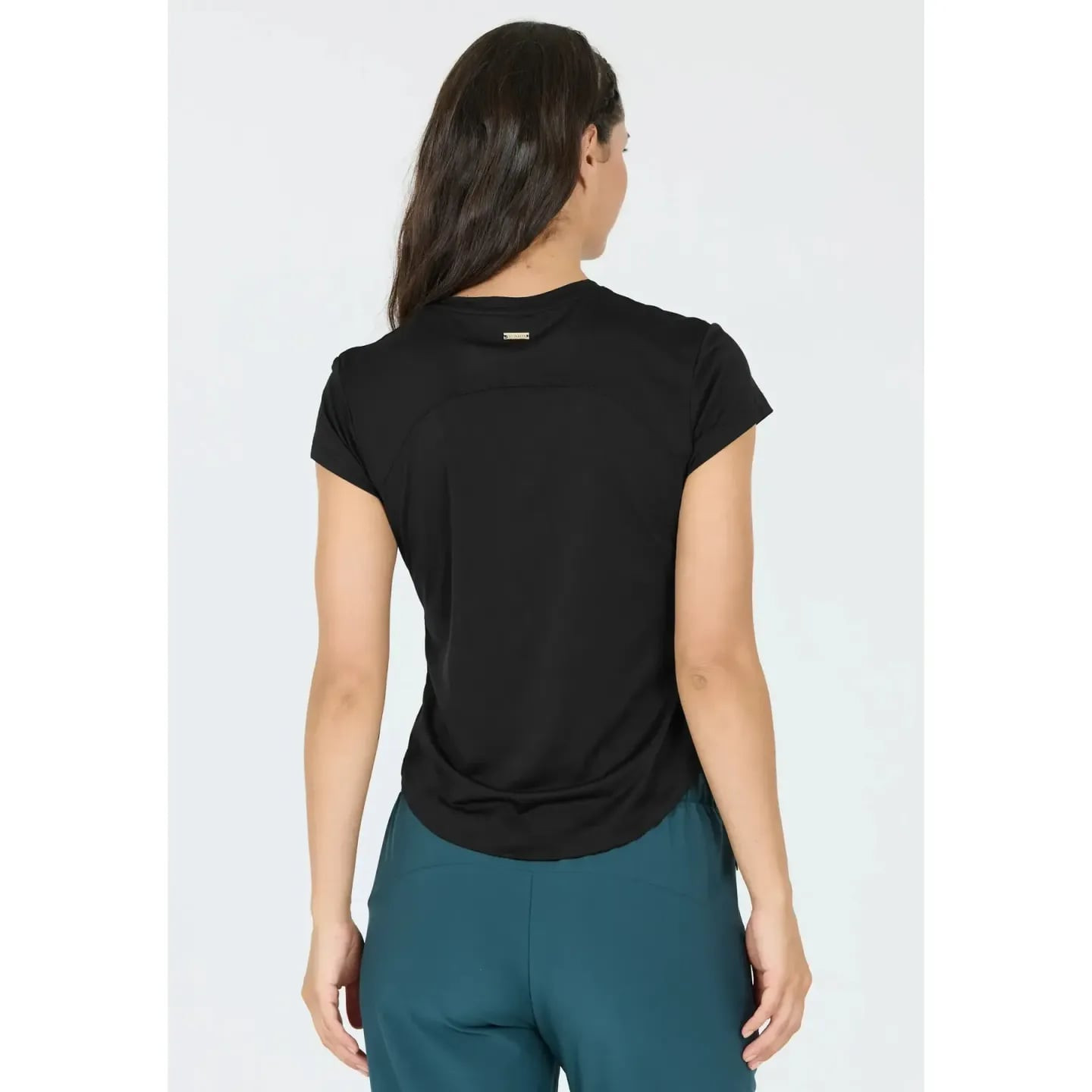 Femme vue de dos portant un t-shirt de sport Athlecia Doja noir à ourlet arrondi