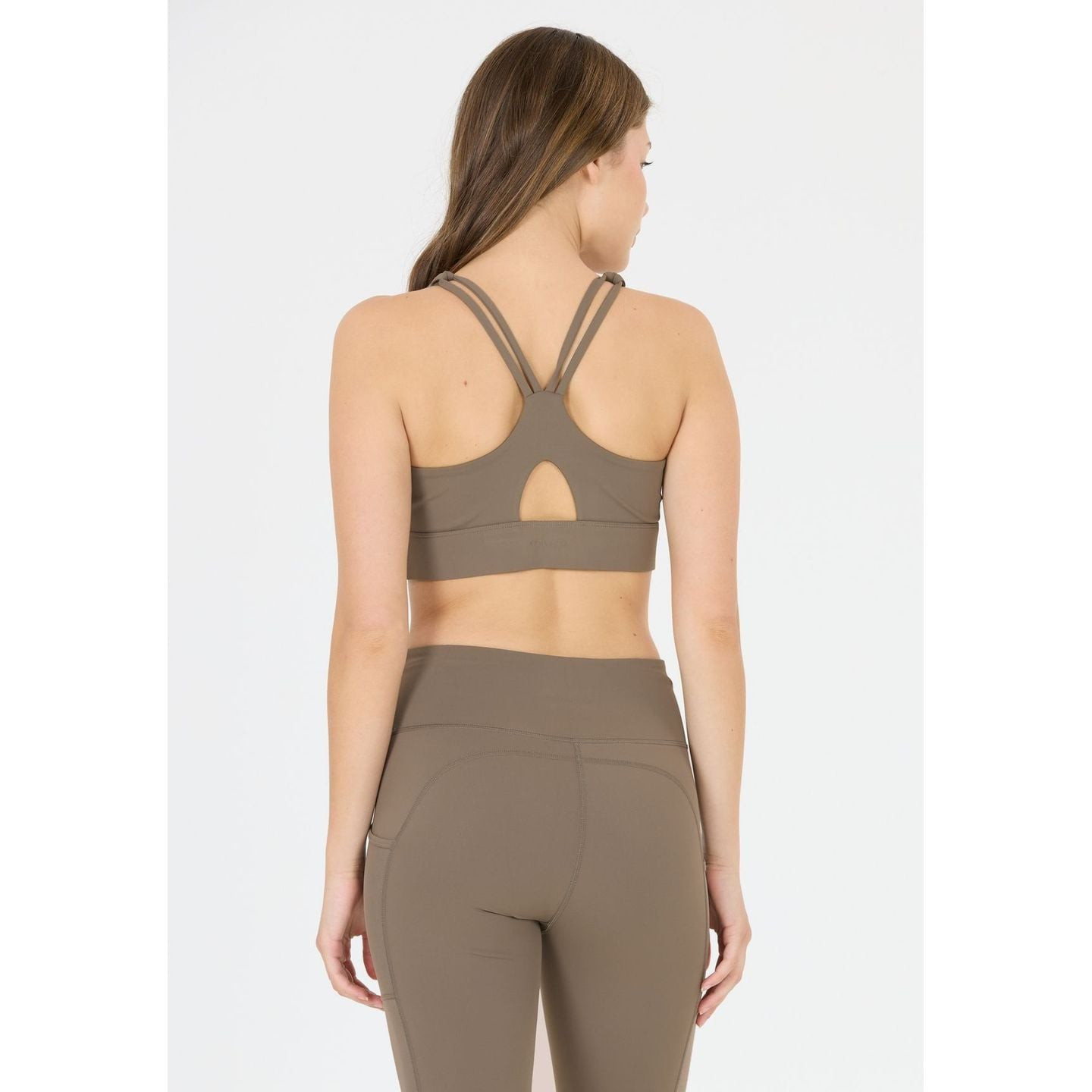 Femme active portant l'Athlecia Brassière De Sport Maintien Moyen Direnna Dos Croisé Femme en extéri