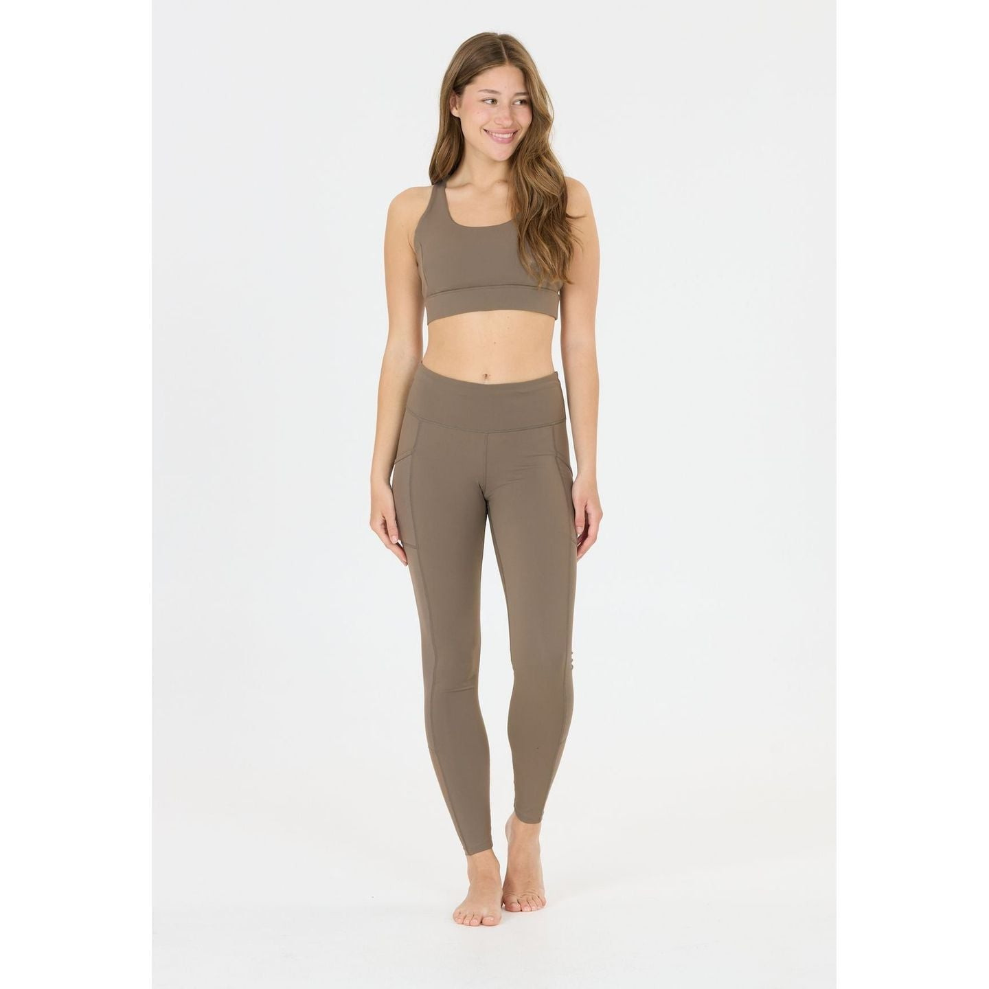 Femme active portant l'Athlecia Brassière De Sport Maintien Moyen Direnna Dos Croisé Femme.