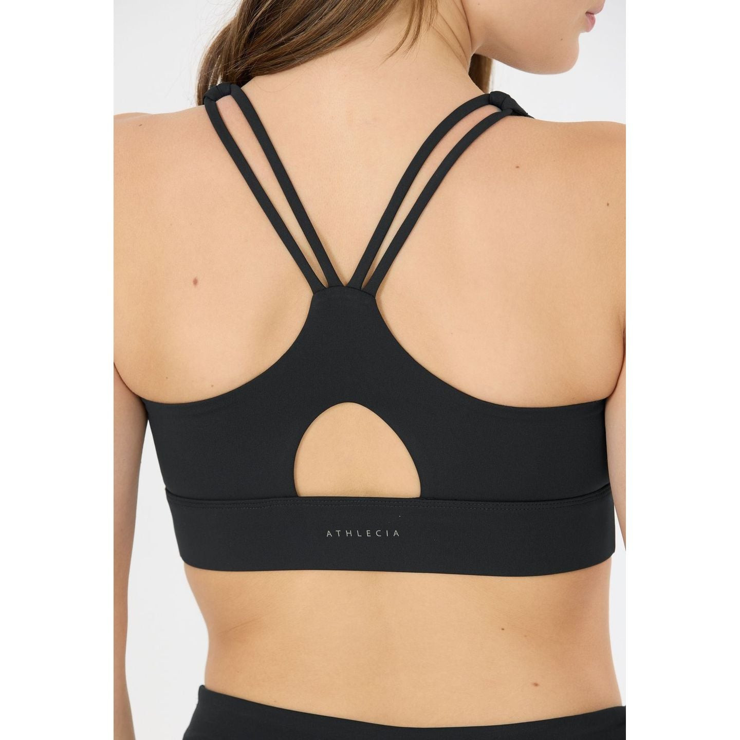 Vue de dos brassière de sport noire Athlecia : doubles bretelles croisées, ouverture en goutte d'eau